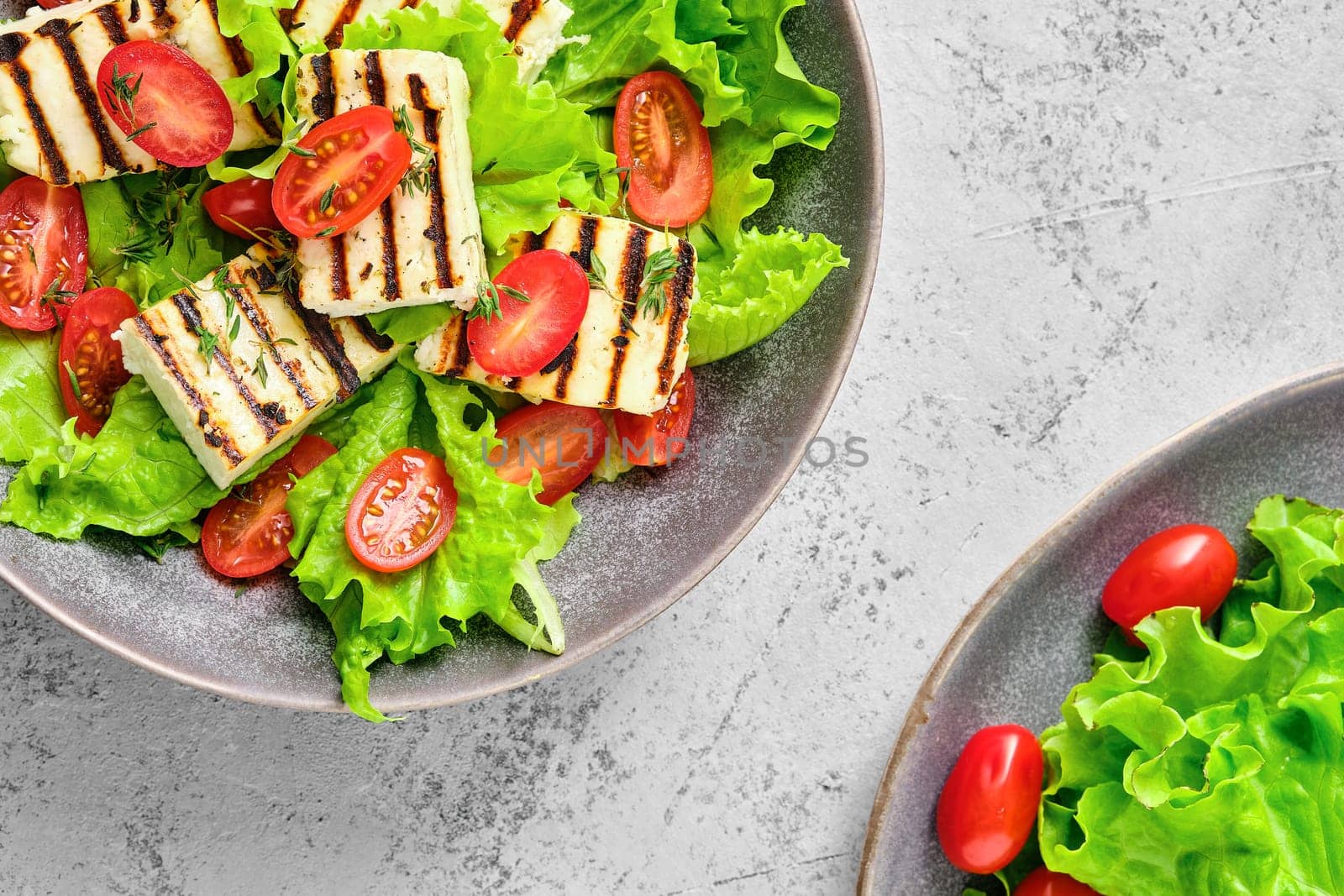 Top view of salad with grilled cheese, tomato and wine sauce