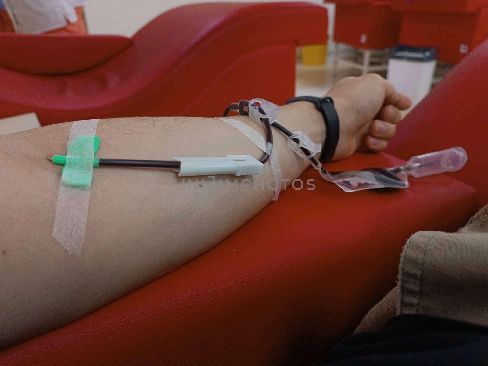 Blood donation, blood transfusion, check specified, fasting, health care. Left arm of caucasian young man with equipment for blood or plasma donations in donation centre. Blood donation concept. Plasma donation concept. Save life concept