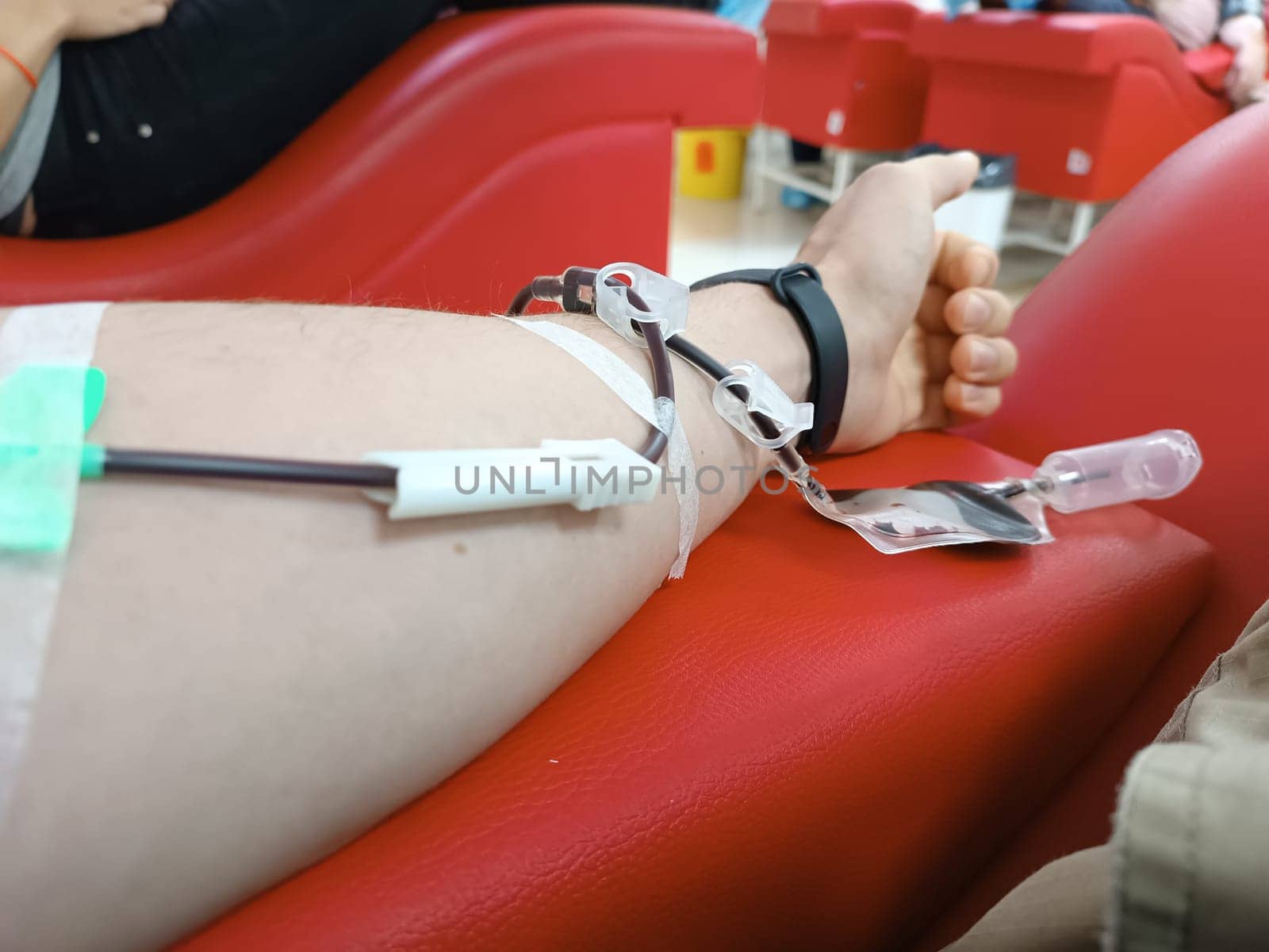 Blood donation, blood transfusion, check specified, fasting, health care. Left arm of caucasian young man with equipment for blood or plasma donations in donation centre. Blood donation concept. Plasma donation concept. Save life concept