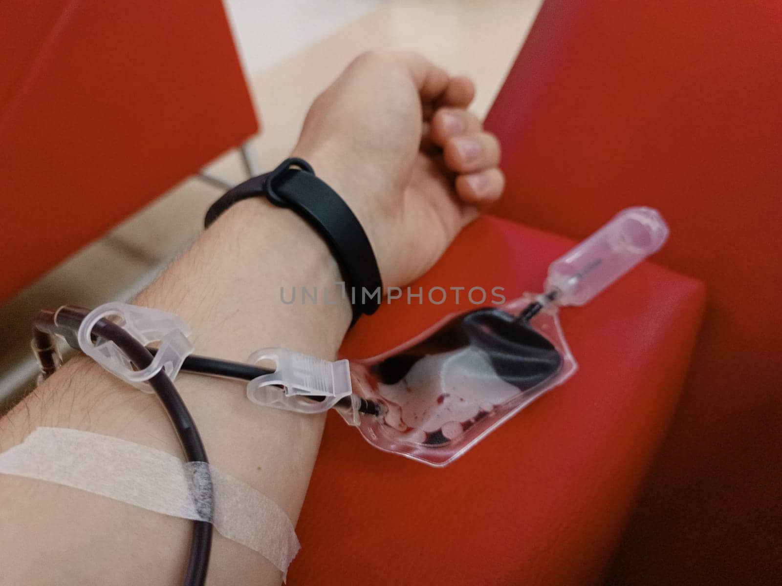 Blood donation, blood transfusion, check specified, fasting, health care. Left arm of caucasian young man with equipment for blood or plasma donations in donation centre. Blood donation concept. Plasma donation concept. Save life concept