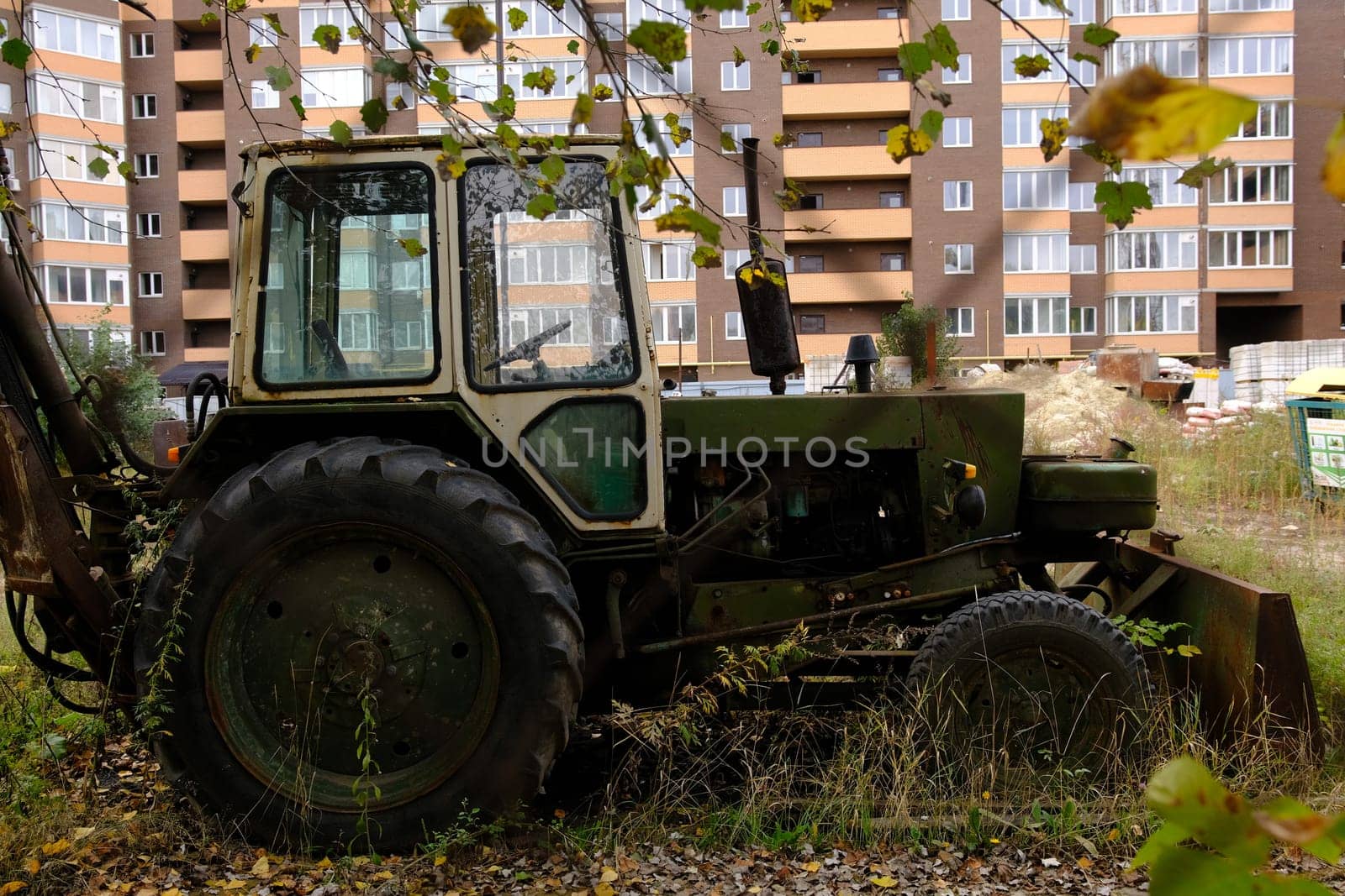 New modern building in process with vintage tractor green color.