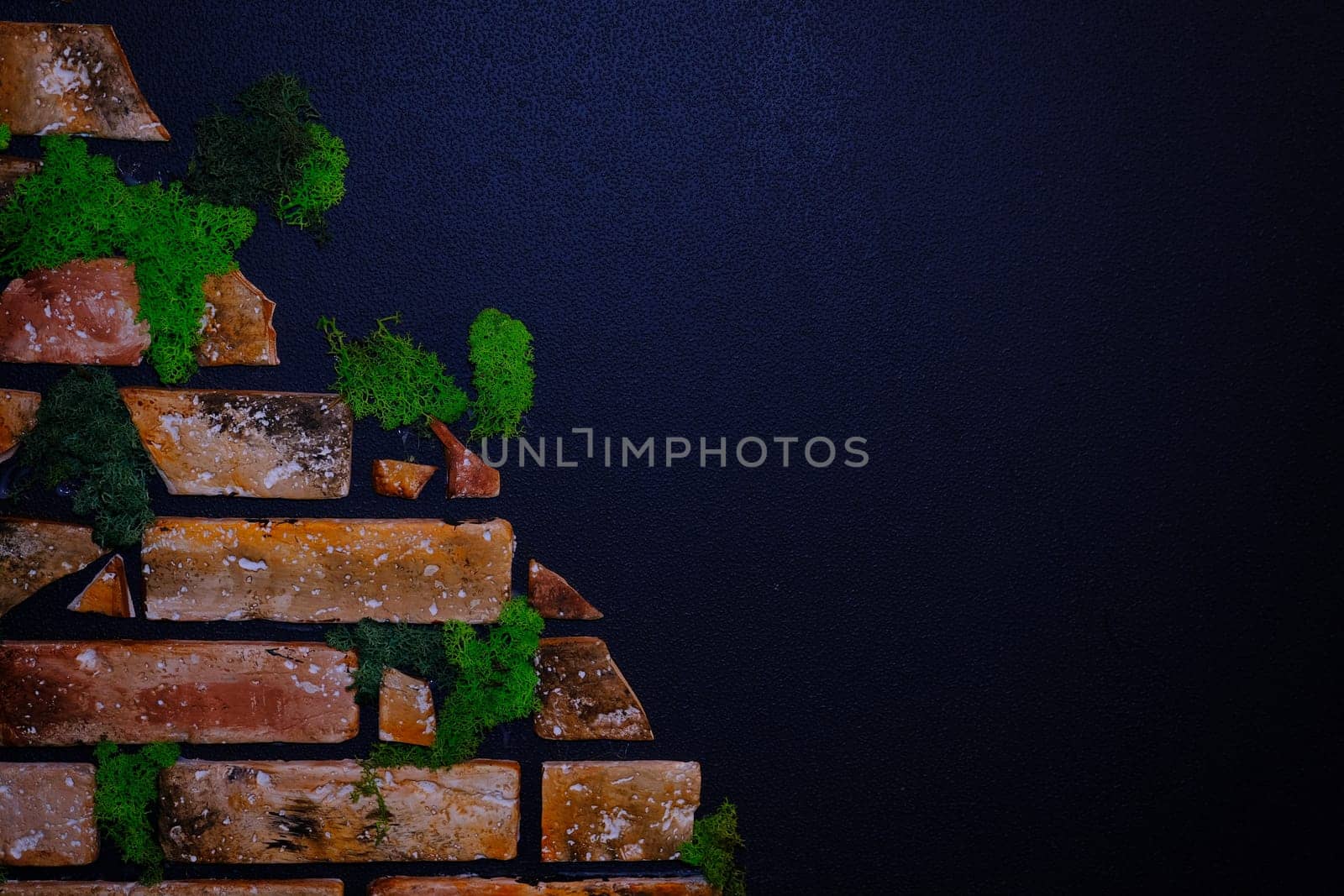 Black wall with bricks in the green moss and wooden clock and warm light. Place for text. Banner concept