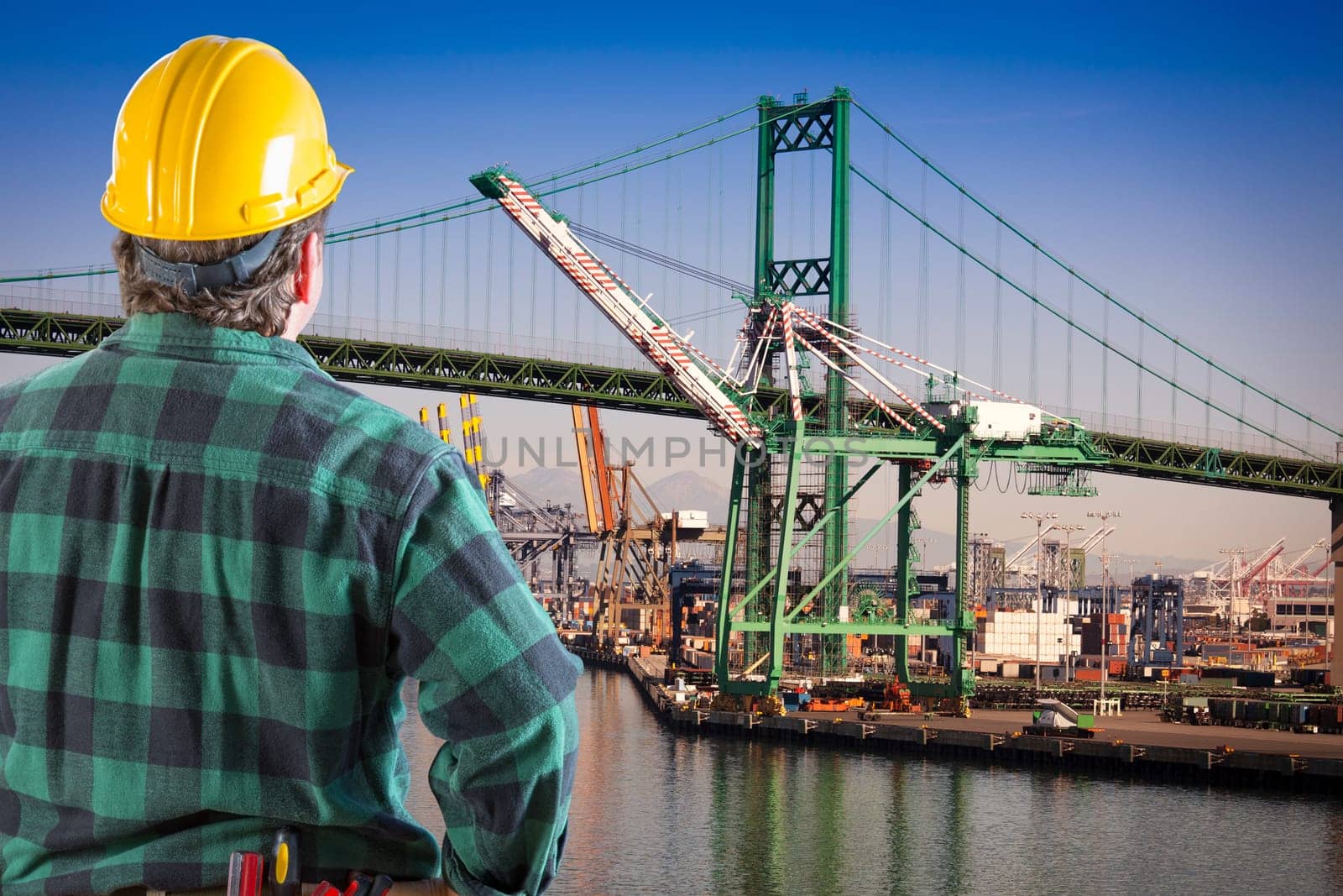 Male Worker Wearing Yellow Hard Hat Overlooking the San Pedro Ship Yard and Bridge.