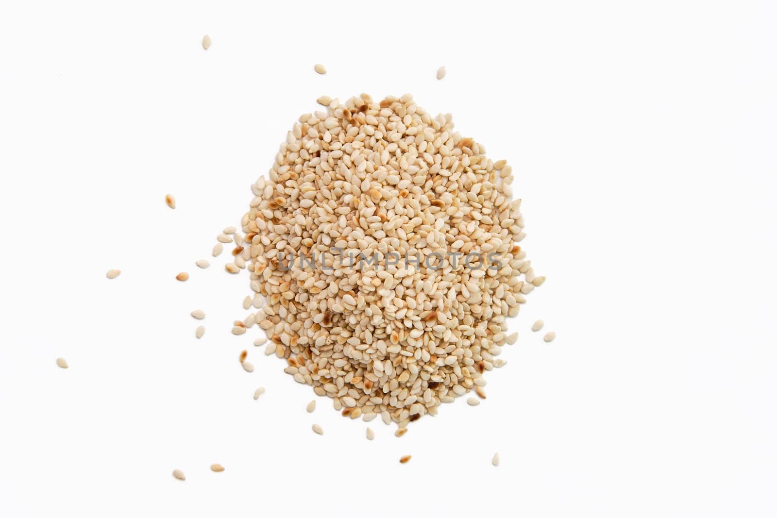 Top view of sesame seeds scattered on white paper