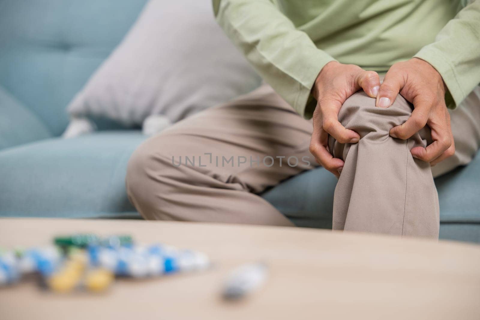 Old age. Asian senior man retirement knee joint pain on sofa, Elderly old man sitting down hands hold knee, Grandfather people health care bone problem at home
