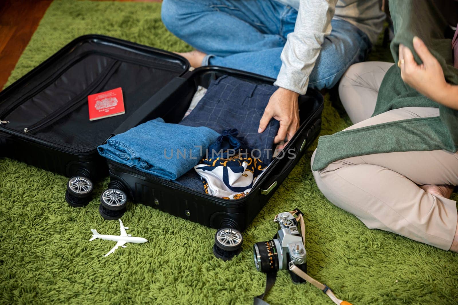 Romantic mature retired packing clothes travel bag suitcase together on floor at home for holiday, Asian couple old senior married retired couple smiling prepare luggage suitcase arranging for travel