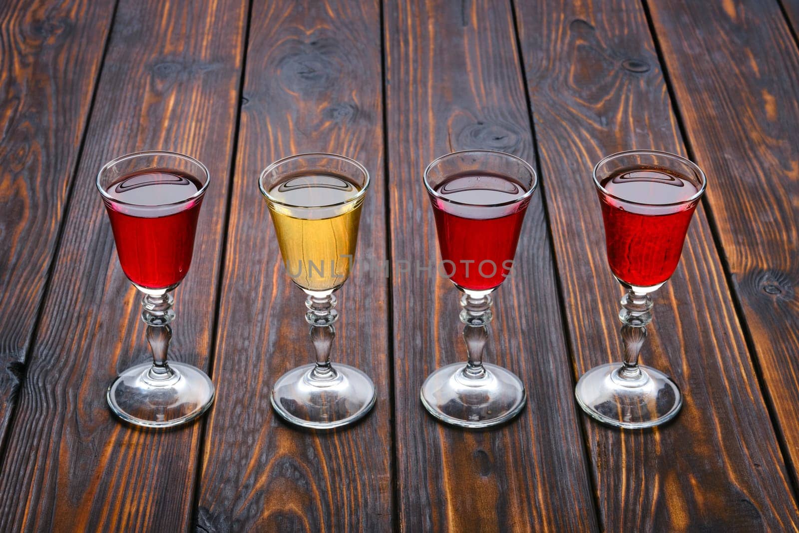 Vodka infused with berries on wooden background (photo with shallow depth of field)