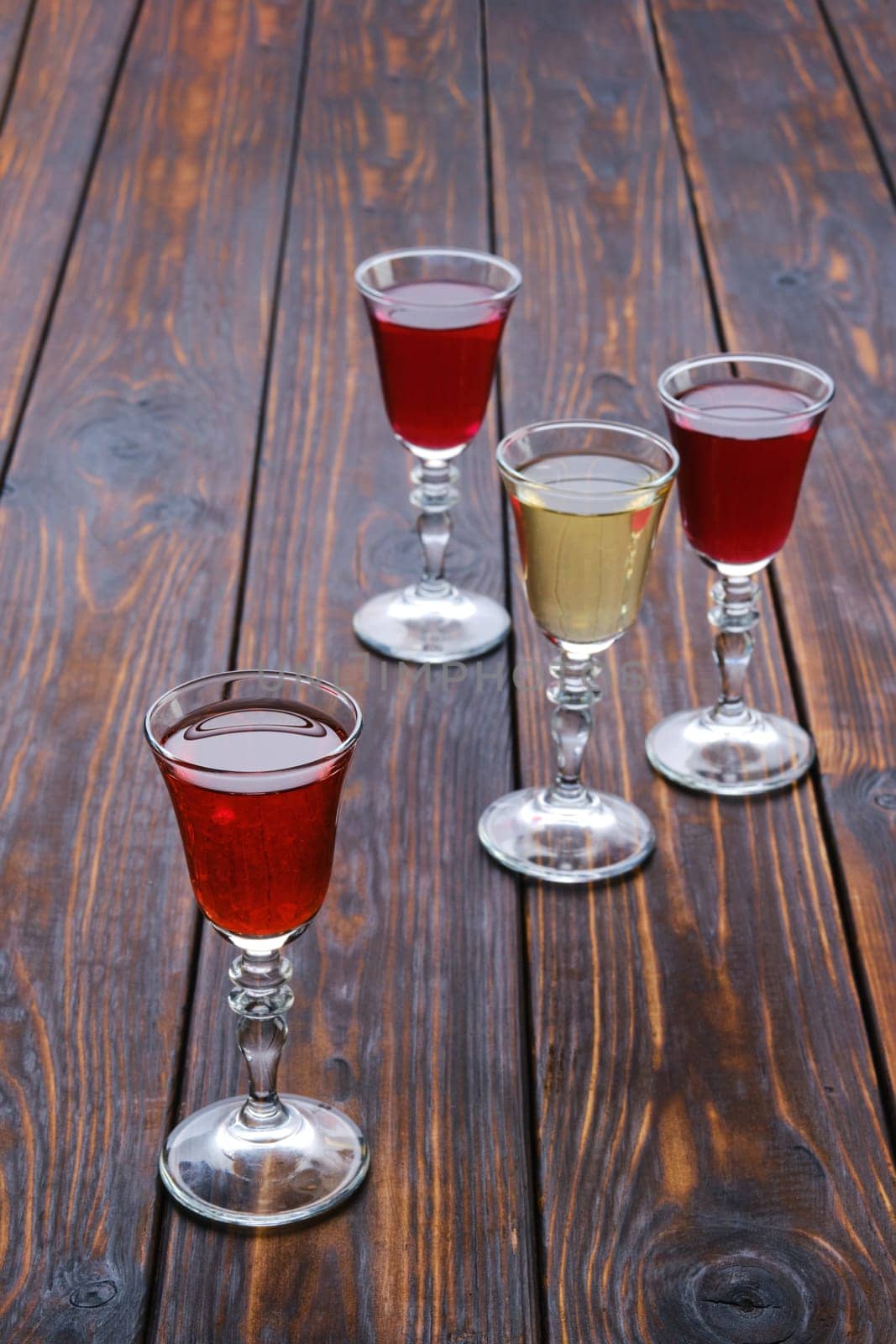 Vodka infused with berries on wooden background (photo with shallow depth of field)