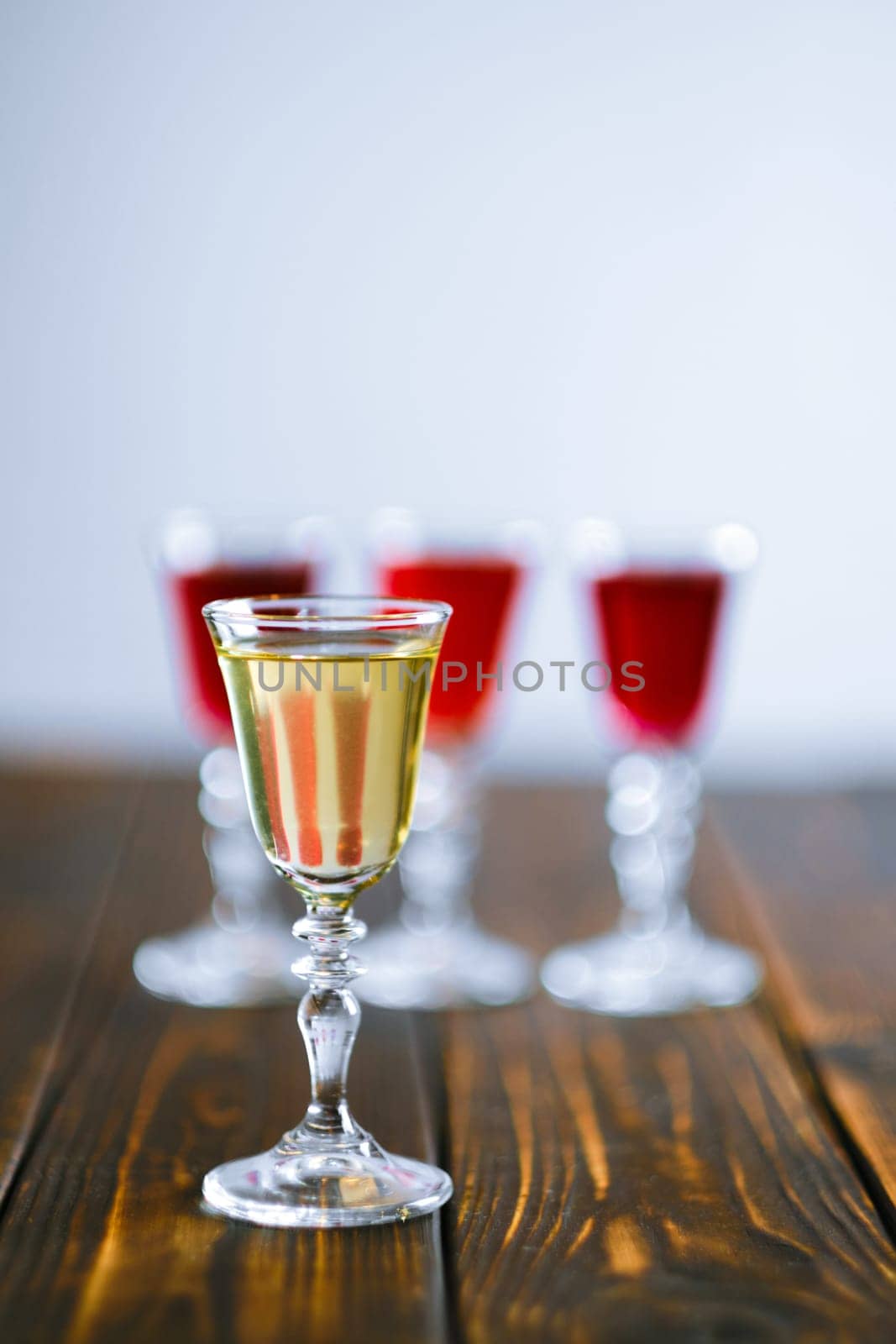 Vodka infused with berries on wooden background (photo with shallow depth of field)