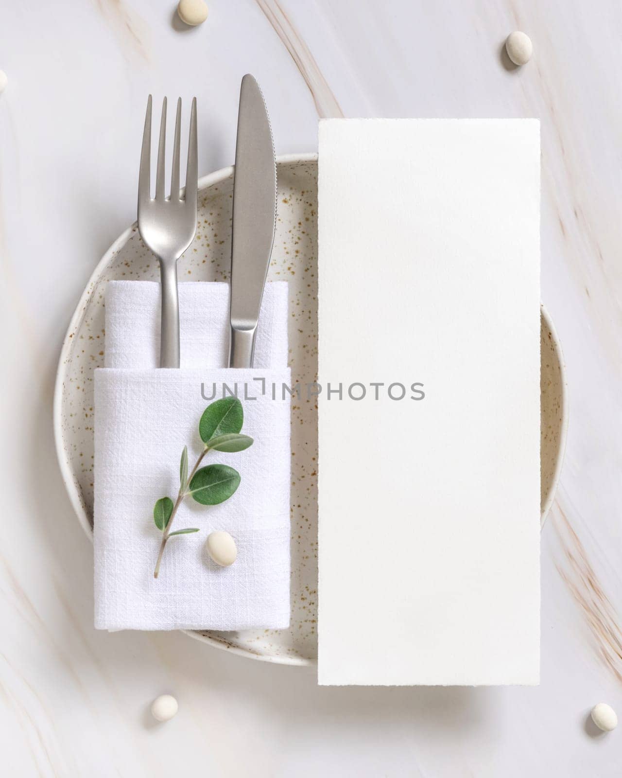 Elegant Table setting with card and envelope decorated with eucalyptus branches top view, Wedding Mockup. Romantic table with vertical paper card. Close to nature and simplicity concepts