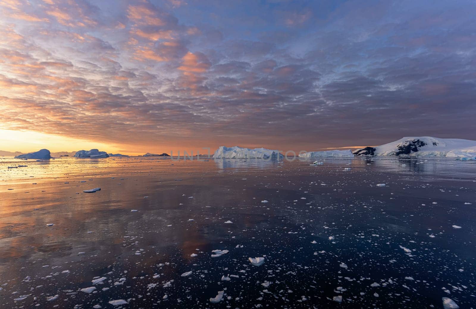 dramatic, colourful sunset / evening atmosphere in Cierva Cove - a deep inlet on the west side of the Antarctic Peninsula, surrounded by Cierva Bay in San Martín Land - Antarctica photographed from an expedition ship
