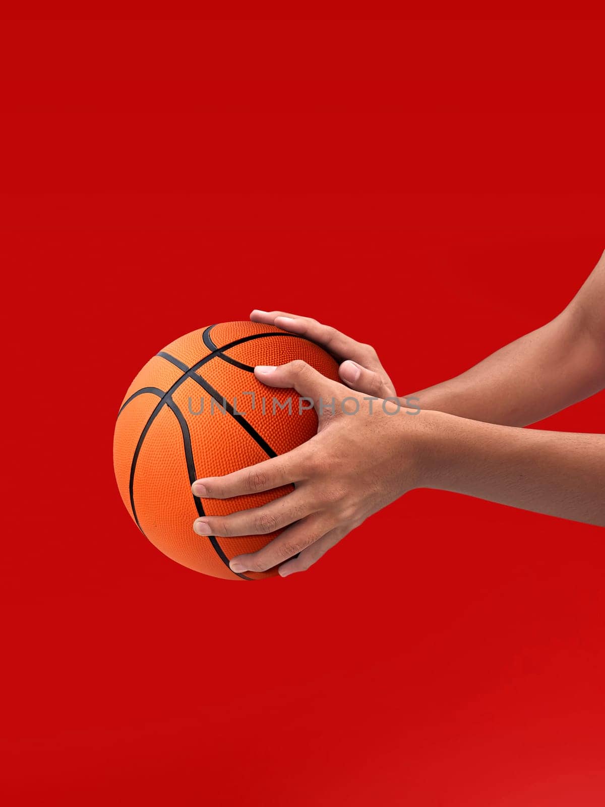 Hands and basketball isolated on red background