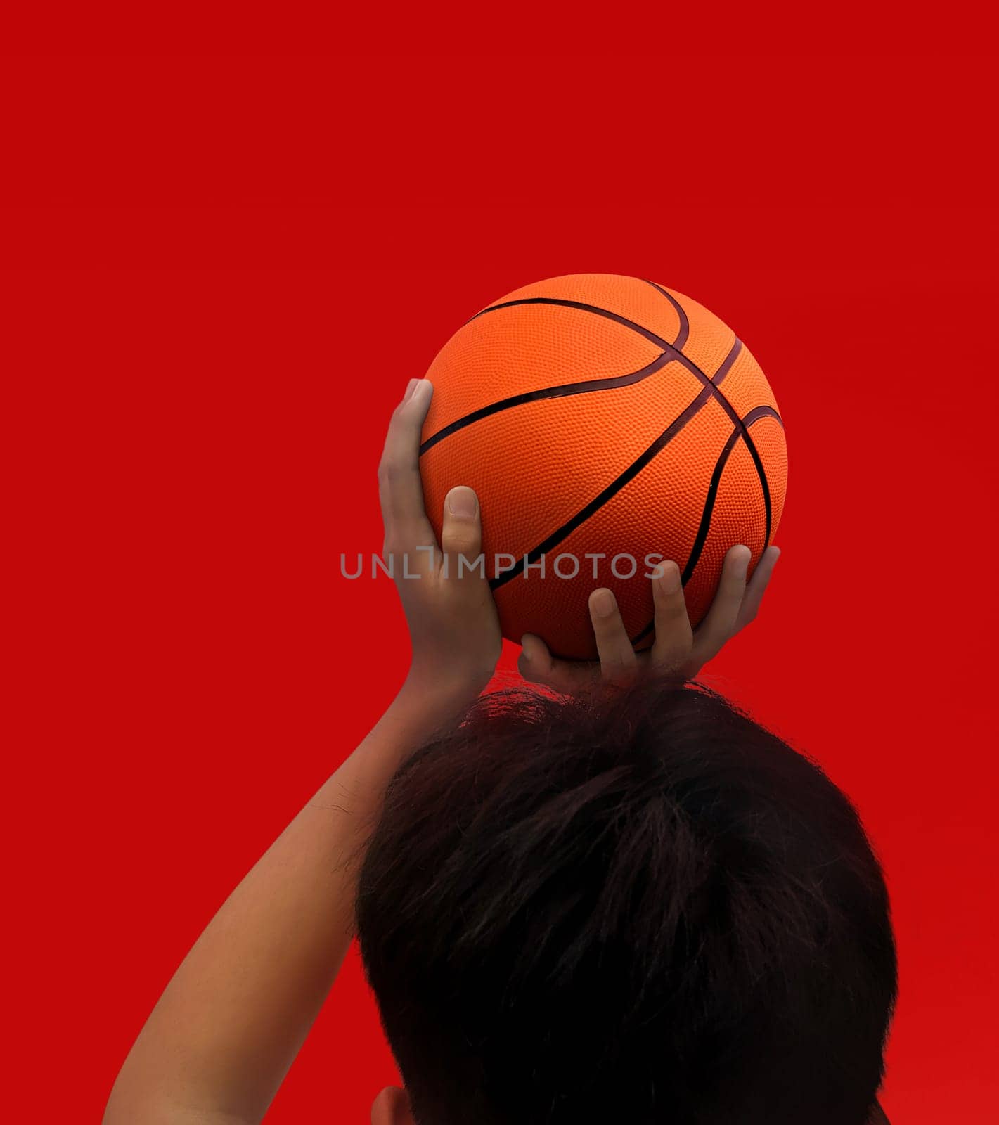 Hands and basketball isolated on red background