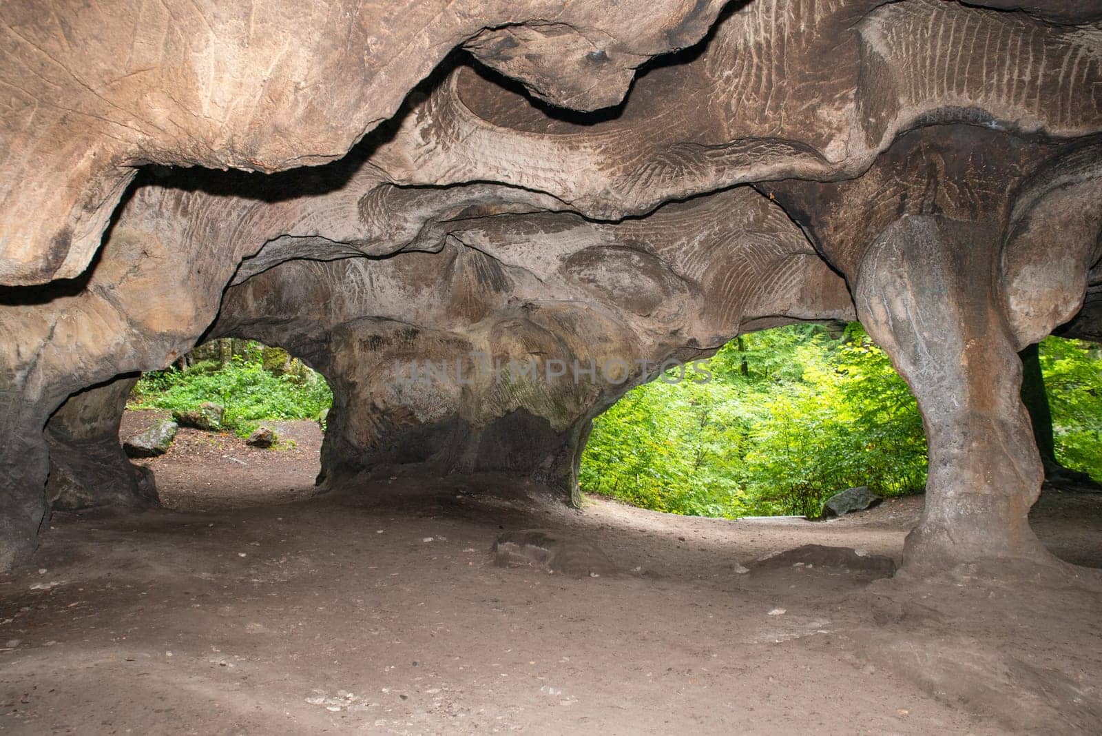 Huel Lee or Hohllay on the Mullerthal trail in Luxembourg, open cave with view to the forest, sandstone rock formation