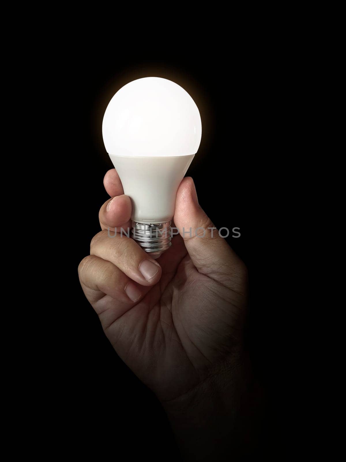 LED lamp in hand on black background