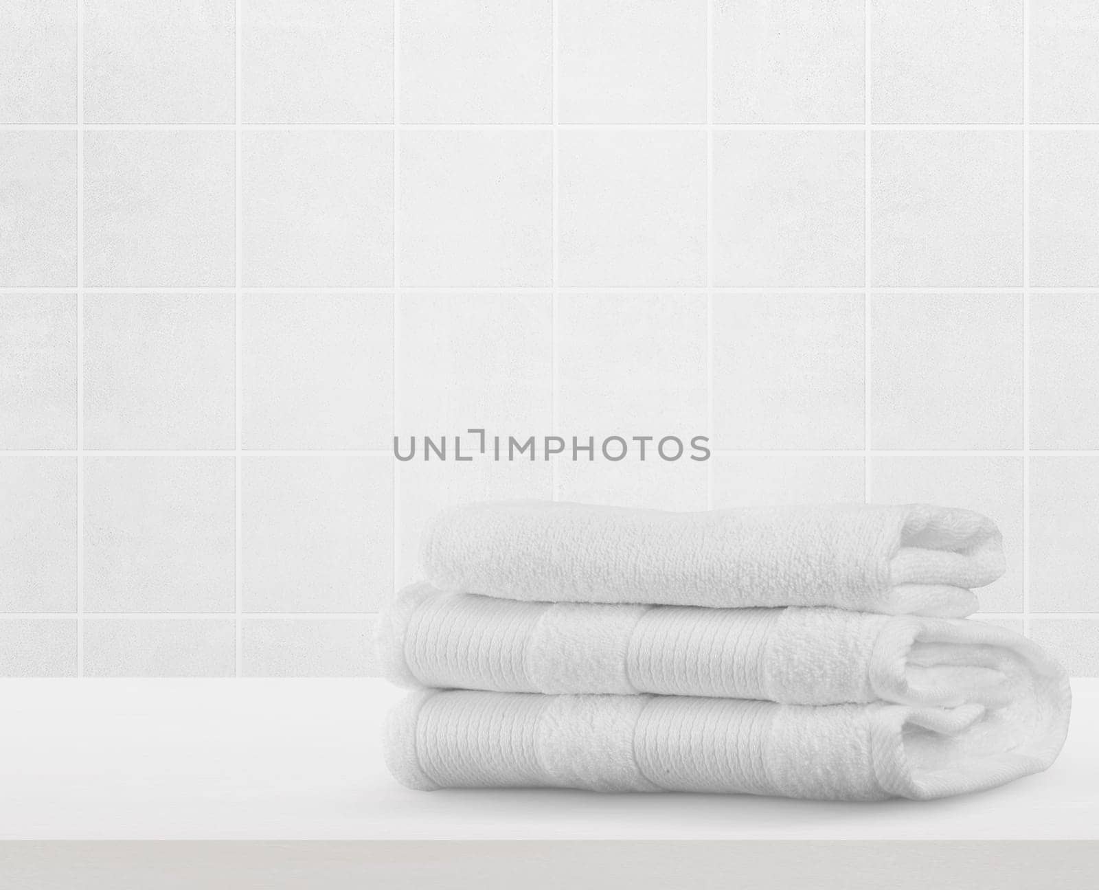 Stack of white clean towels on table in bathroom