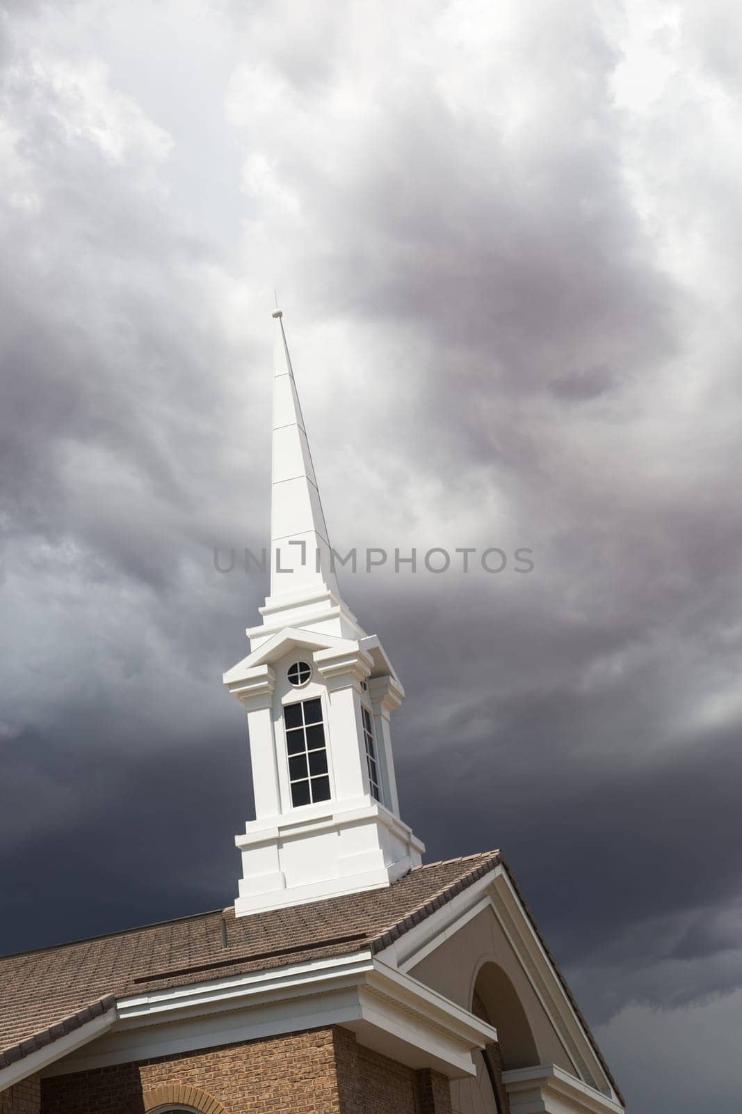 Church Steeple Tower Below Ominous Stormy Thunderstorm Clouds.