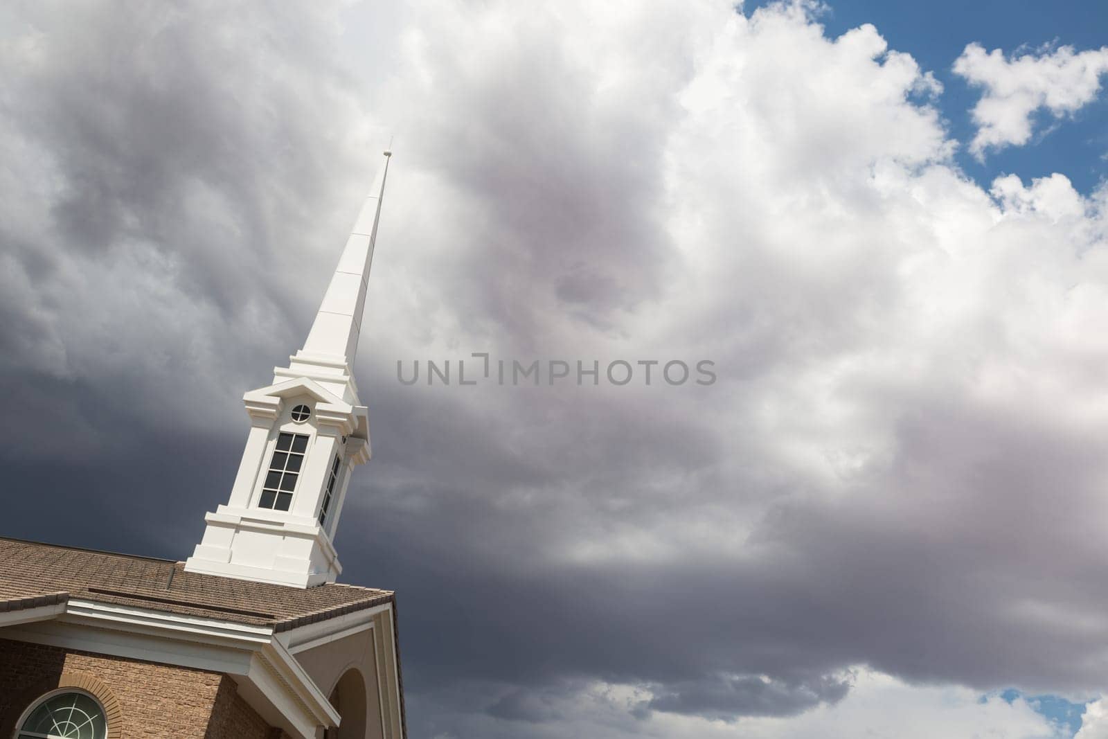 Church Steeple Tower Below Ominous Stormy Thunderstorm Clouds.