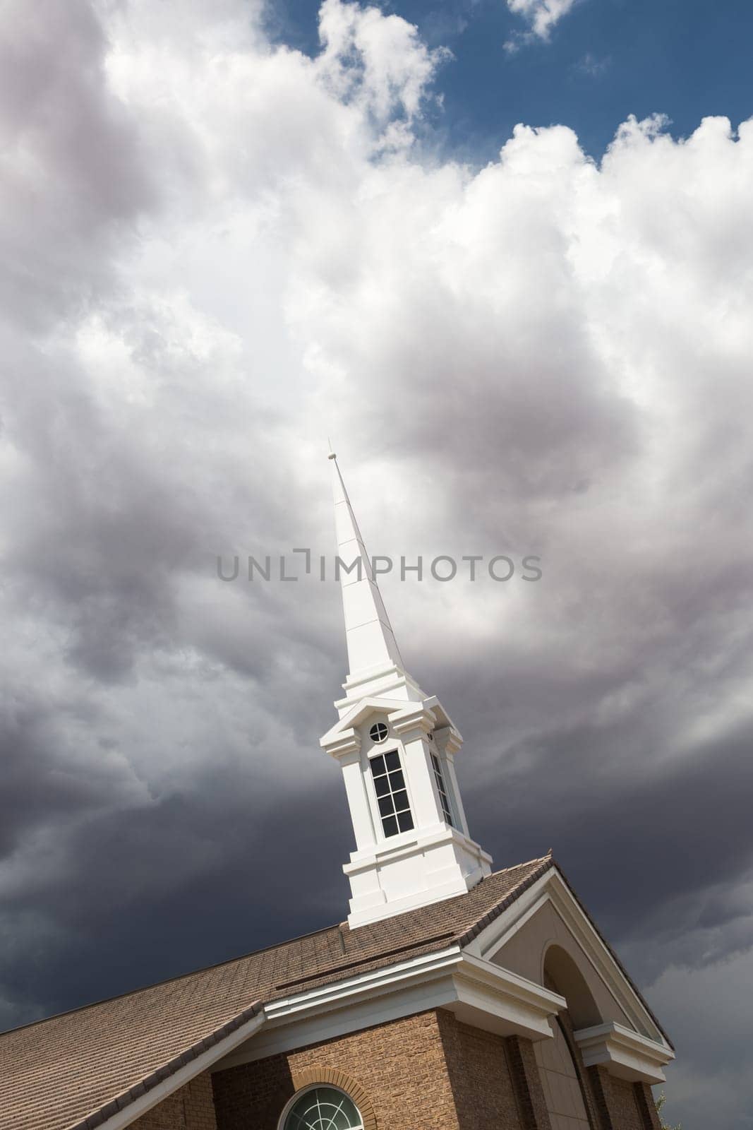 Church Steeple Tower Below Ominous Stormy Thunderstorm Clouds.