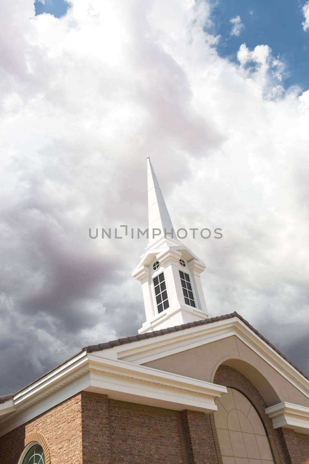Church Steeple Tower Below Ominous Stormy Thunderstorm Clouds.