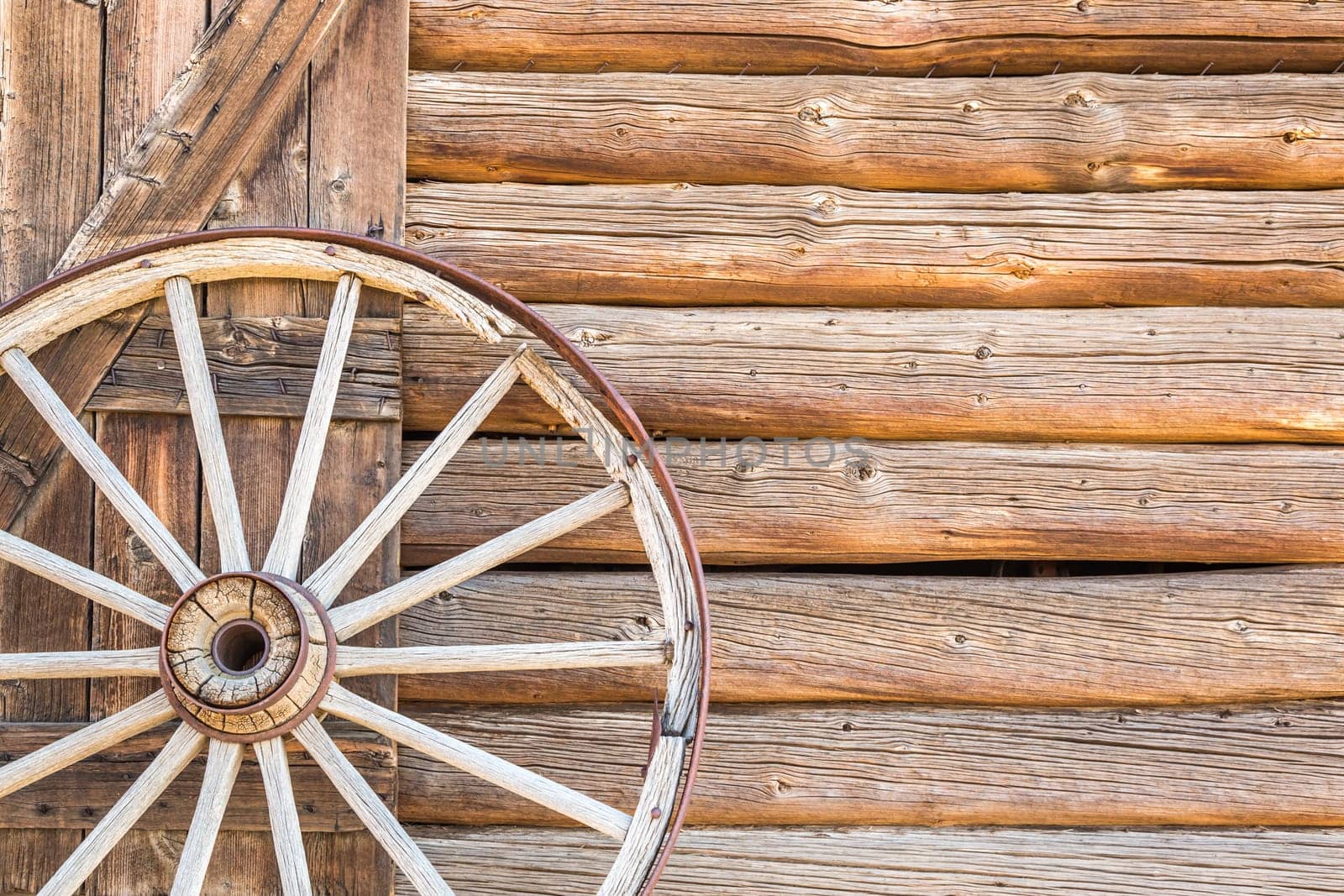 Abstract of Vintage Antique Log Cabin Wall and Wagon Wheel.