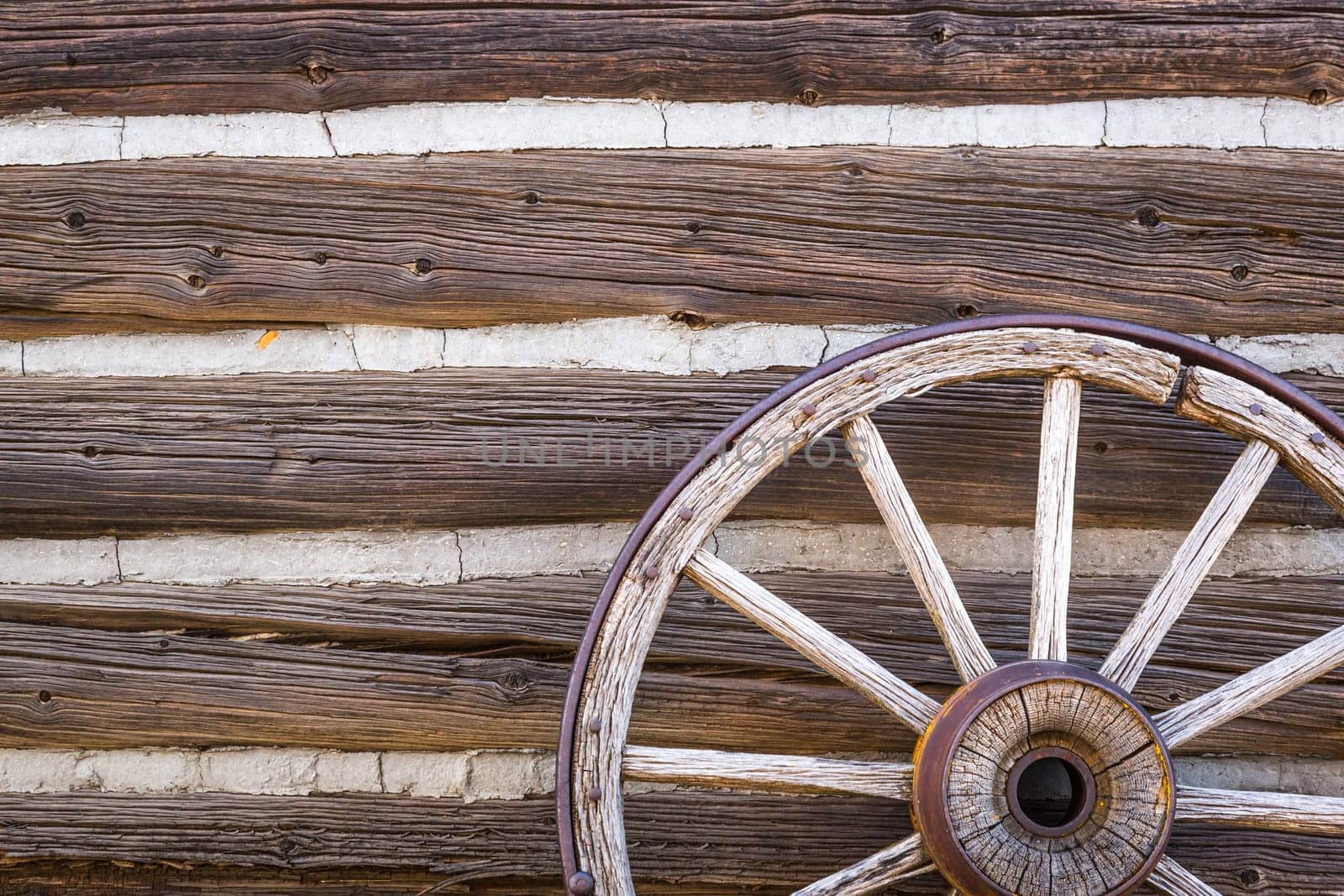 Abstract of Vintage Antique Log Cabin Wall and Wagon Wheel.