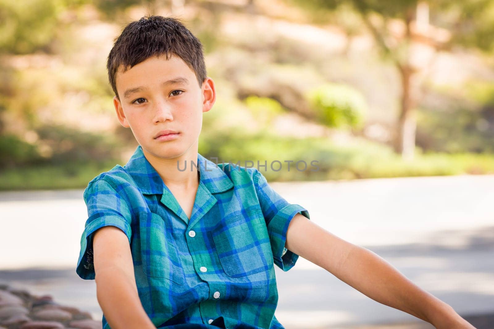 Outdoor portrait of a biracial Chinese and Caucasian boy.