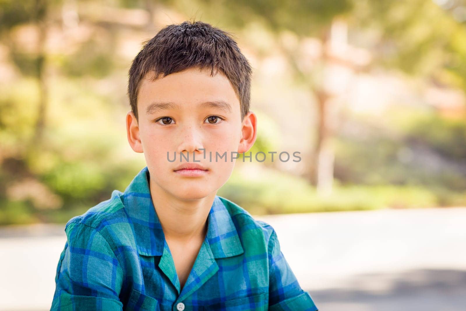Outdoor portrait of a biracial Chinese and Caucasian boy.