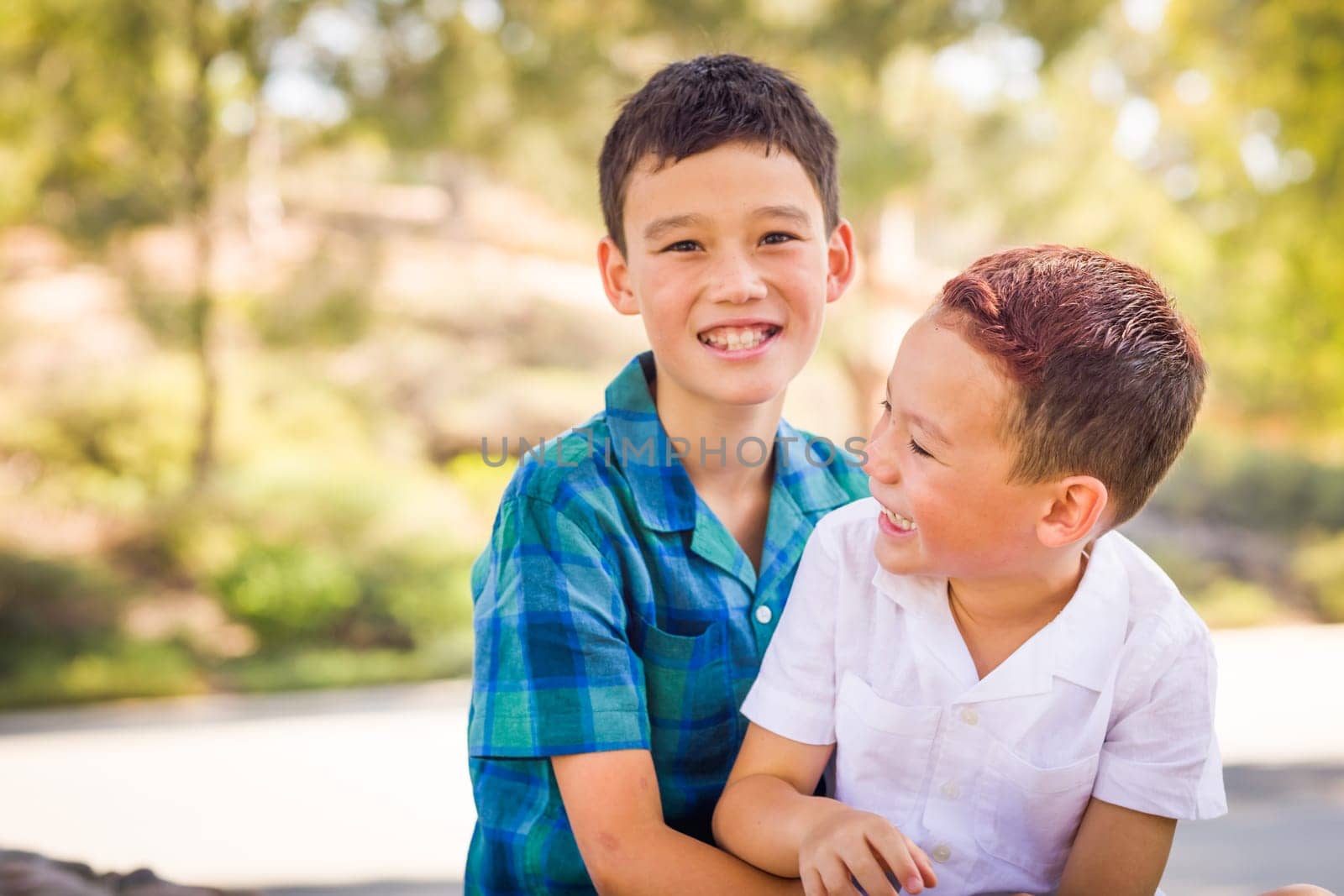 Outdoor portrait of biracial Chinese and Caucasian brothers having fun.