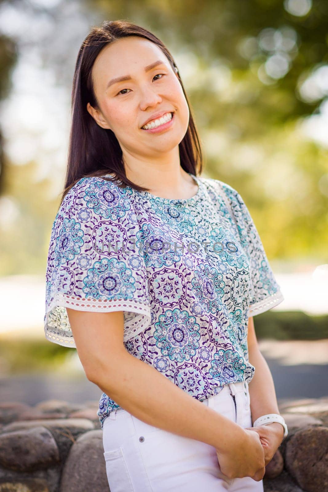Outdoor portrait of a happy Chinese young adult woman.
