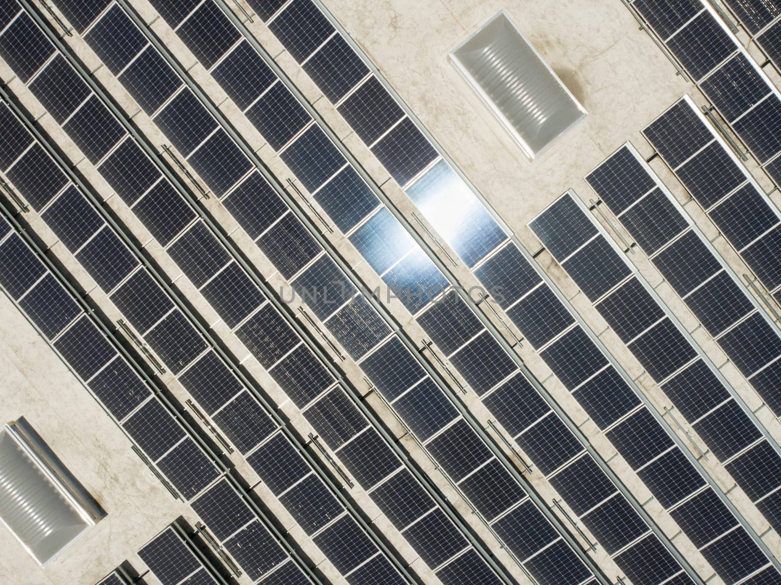 Aerial View of Solar Panels Mounted on Roof of Large Industrial Building or Warehouse.