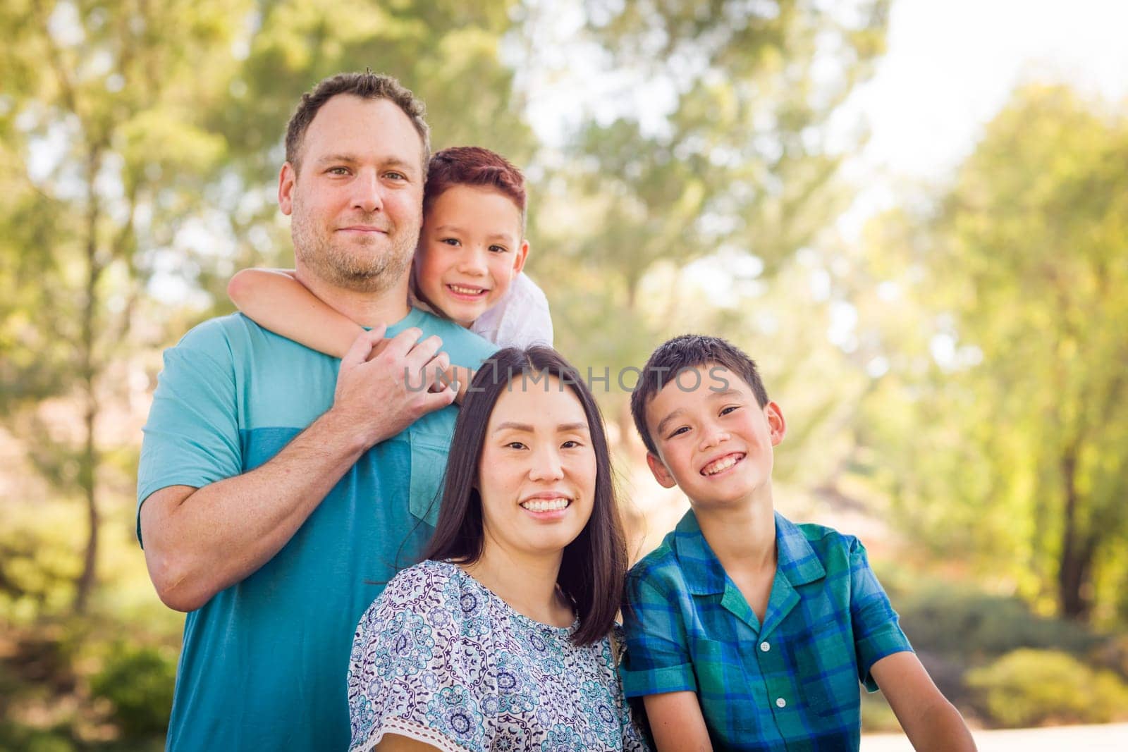 Outdoor portrait of biracial Chinese and Caucasian family.