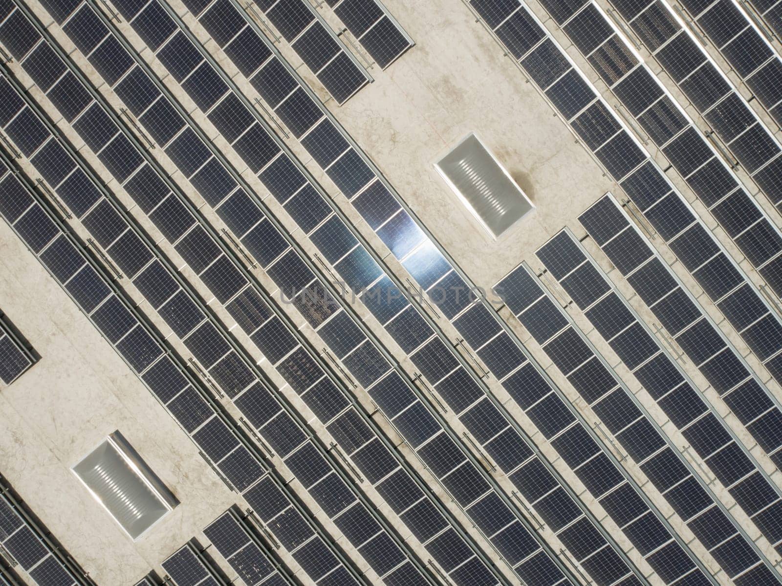 Aerial View of Solar Panels Mounted on Roof of Large Industrial Building or Warehouse.