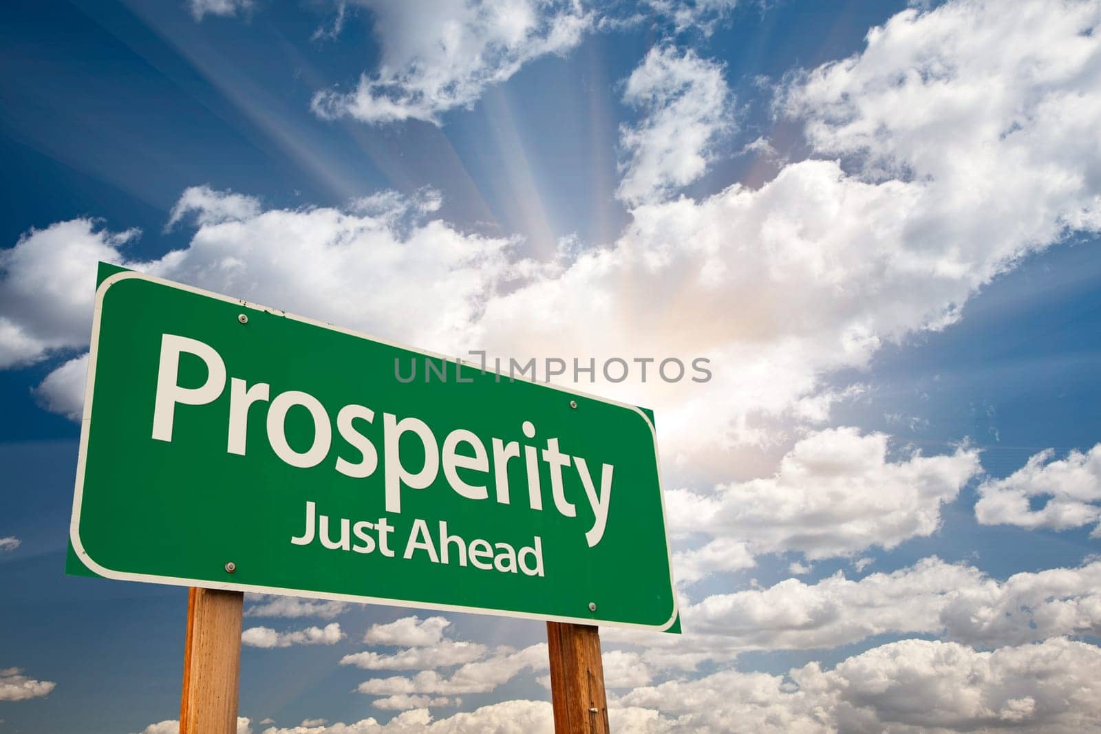 Prosperity Green Road Sign Over Sunny Dramatic Clouds and Sky.