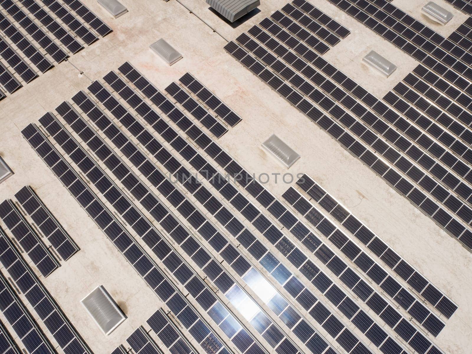 Aerial View of Solar Panels Mounted on Roof of Large Industrial Building or Warehouse.