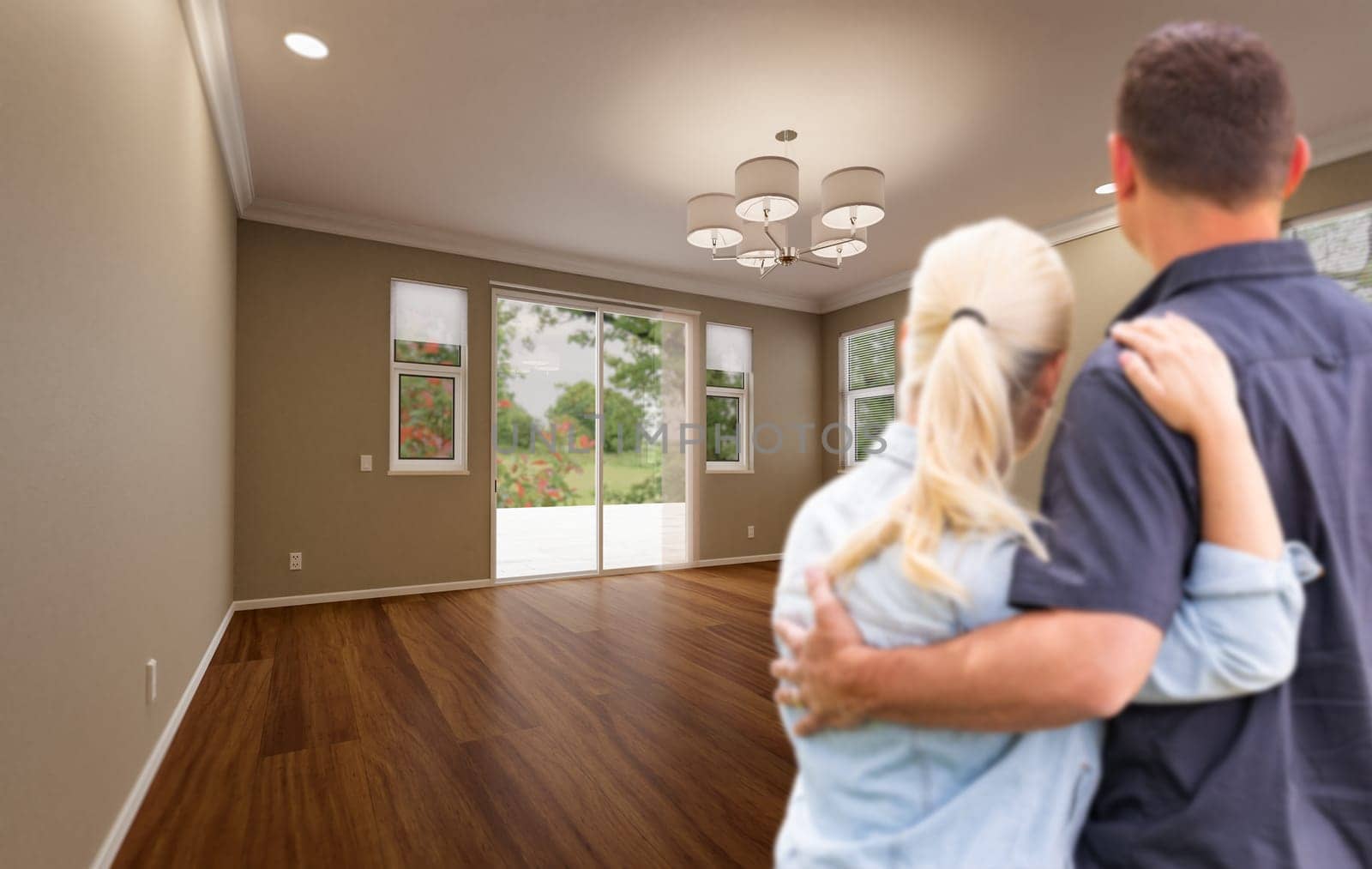 Young Adult Couple Looking At Empty Room of New House.