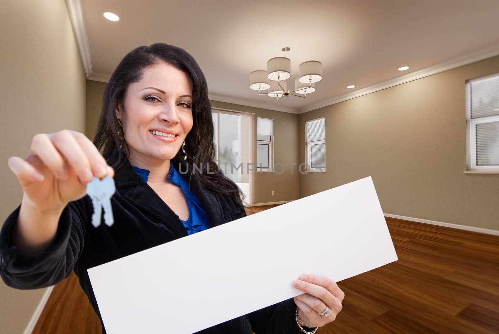 Hispanic Woman With House Keys and Blank Sign In Empty Room of House.