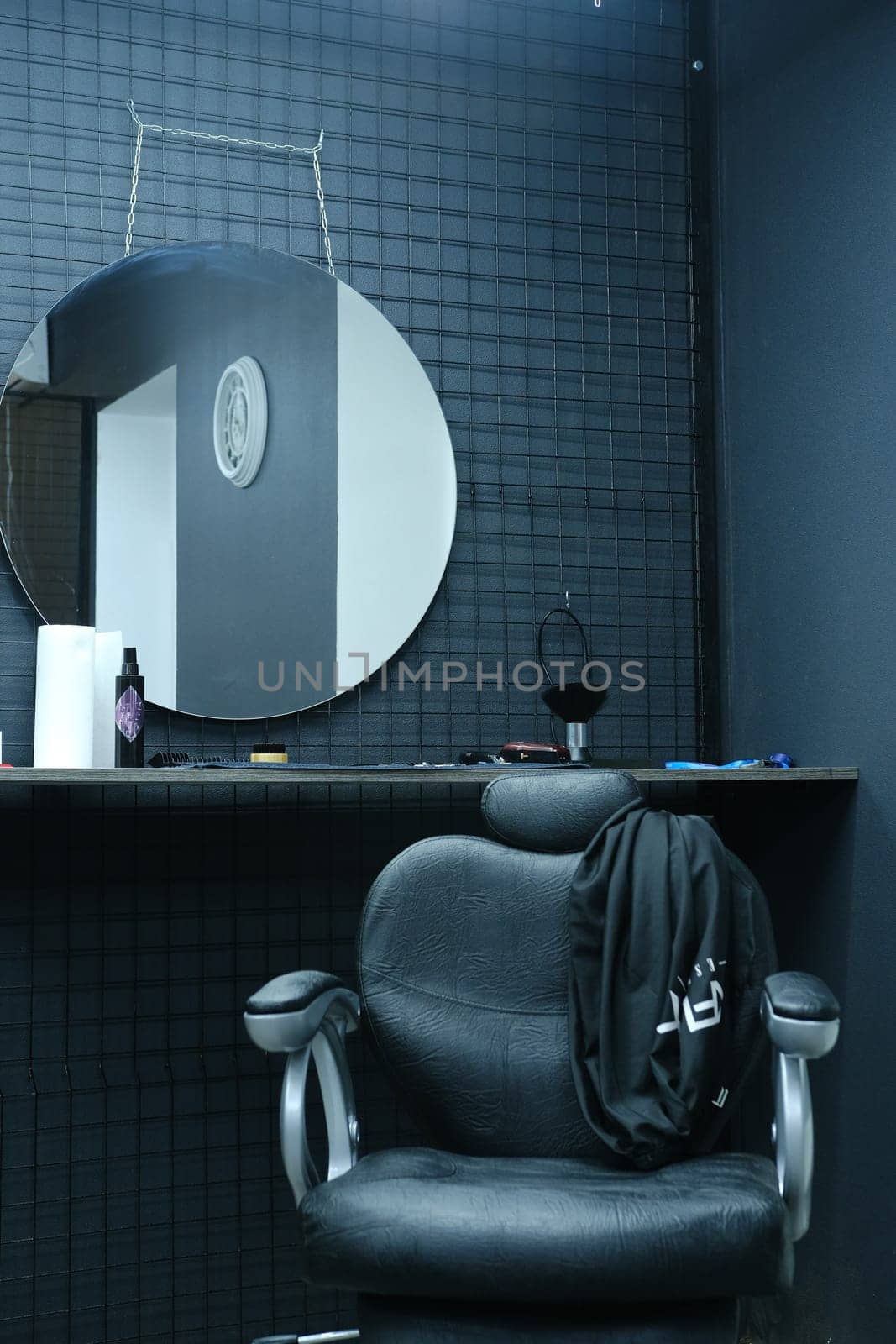 Client's chair in barber shop from black leather in black interior.