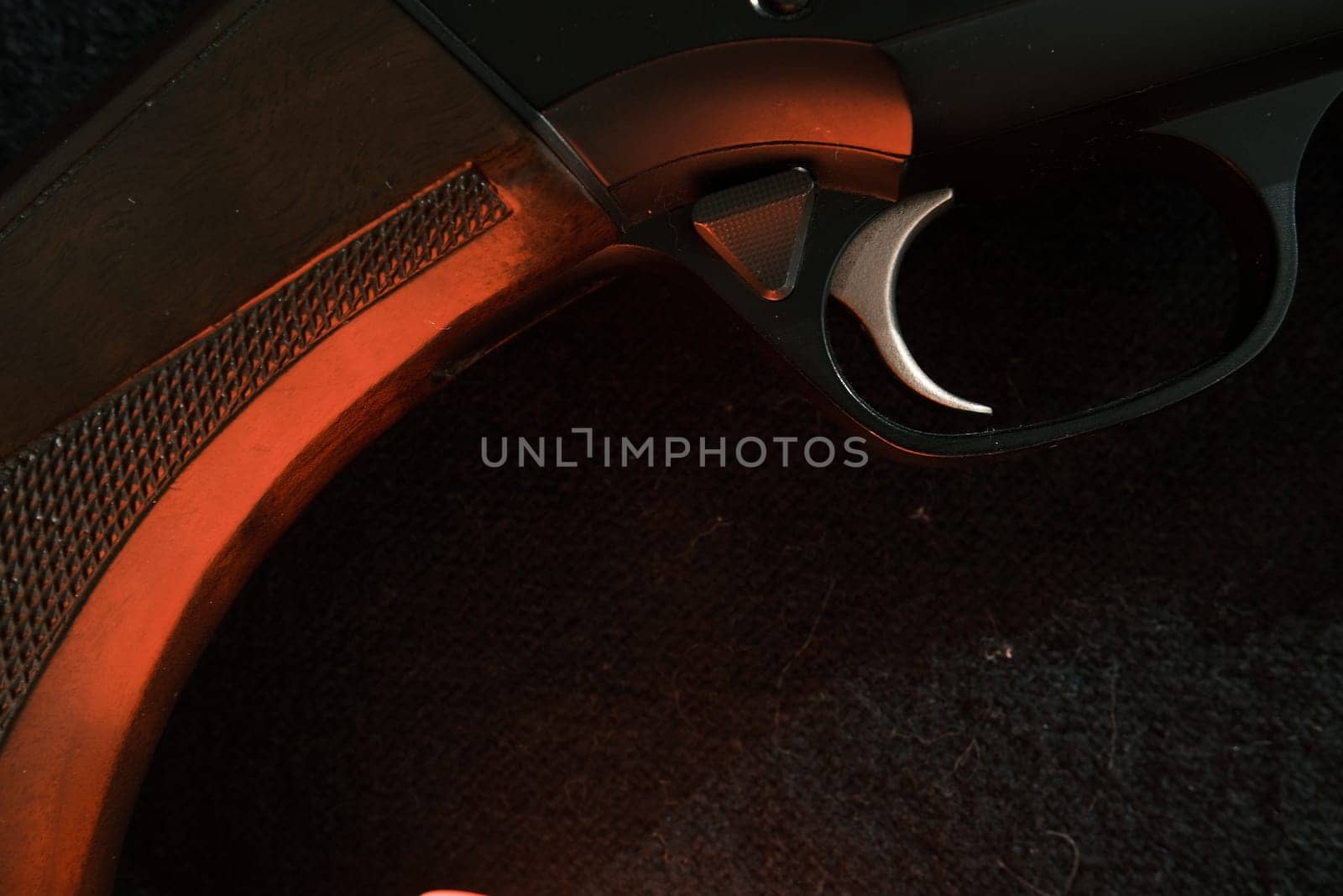 Trigger of a rifle on black background with red lightning.