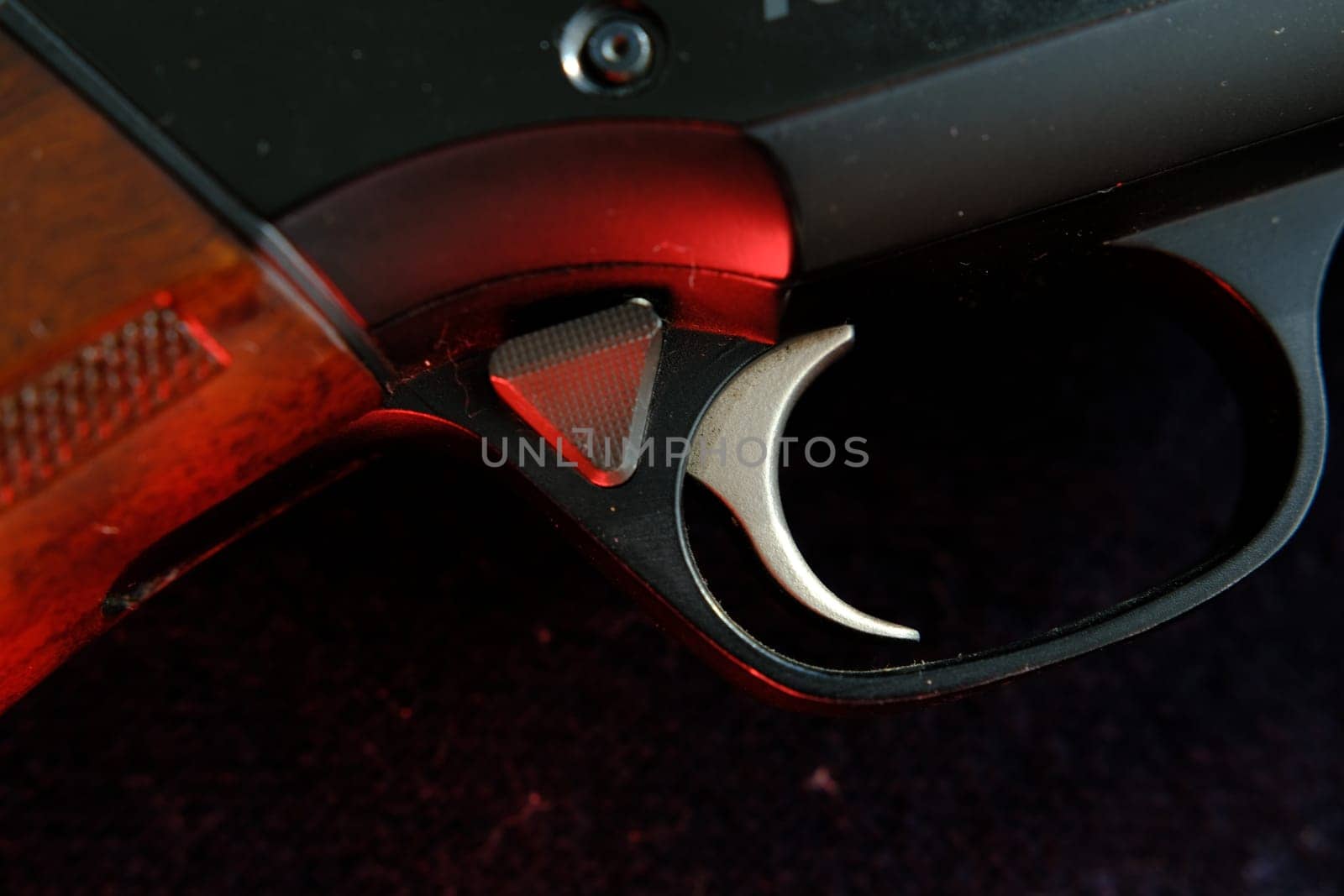 Trigger of a rifle on black background with red lightning.