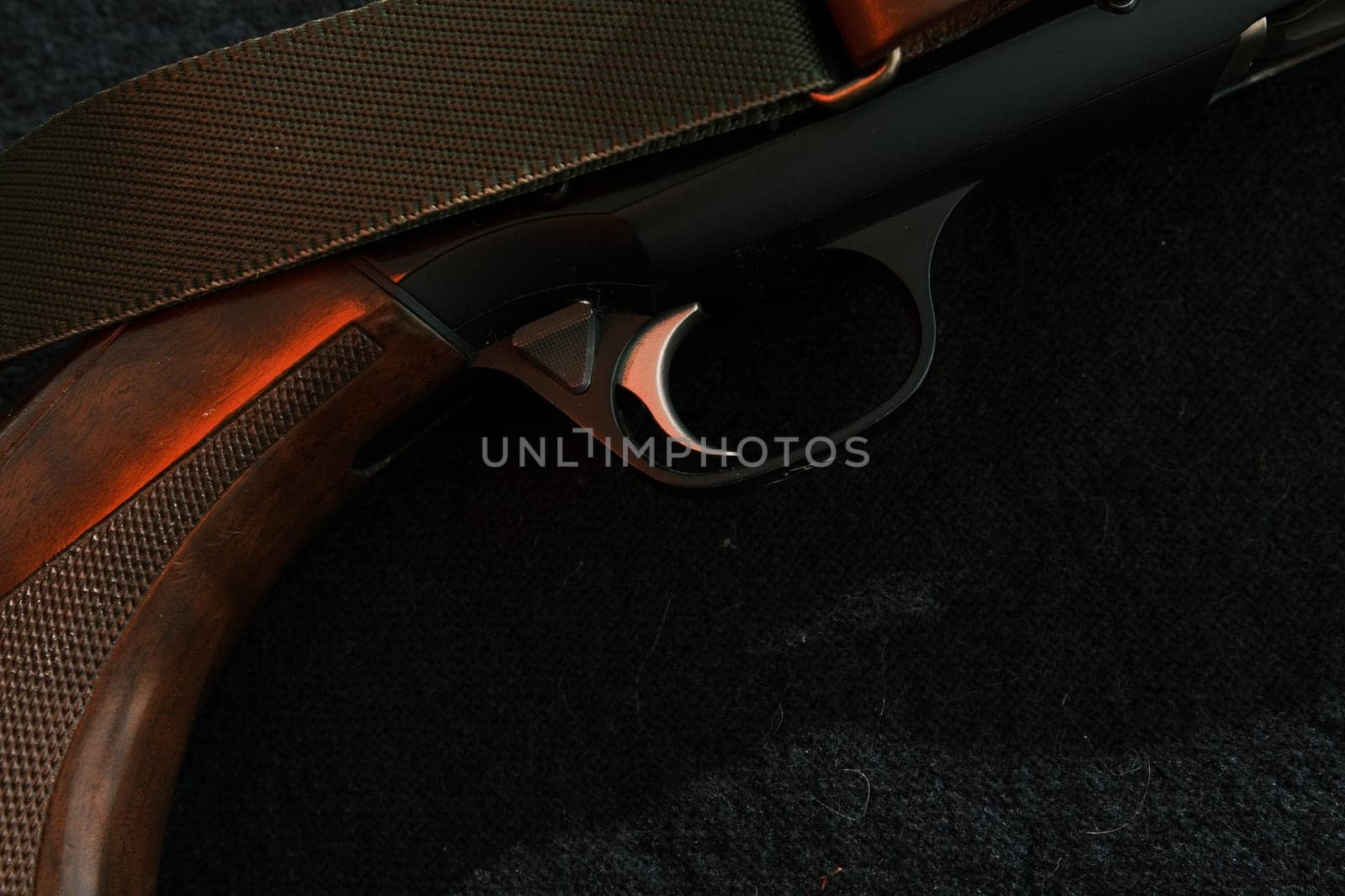 Trigger of a rifle on black background with red lightning.