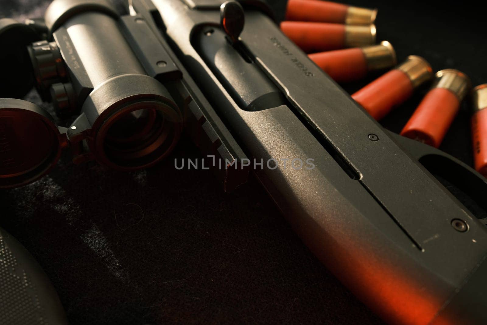 Closeup shotgun shutter. Hunting semi-automatic shotgun with wooden butt on dark background.