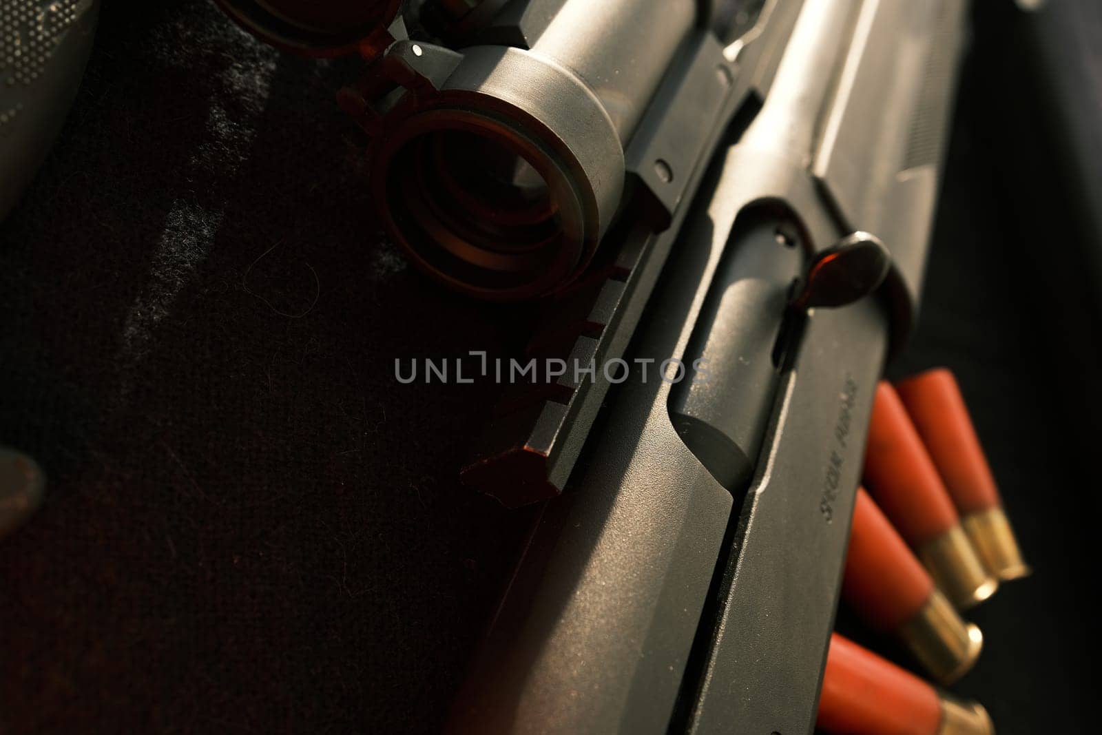 Closeup shotgun shutter. Hunting semi-automatic shotgun with wooden butt on dark background.