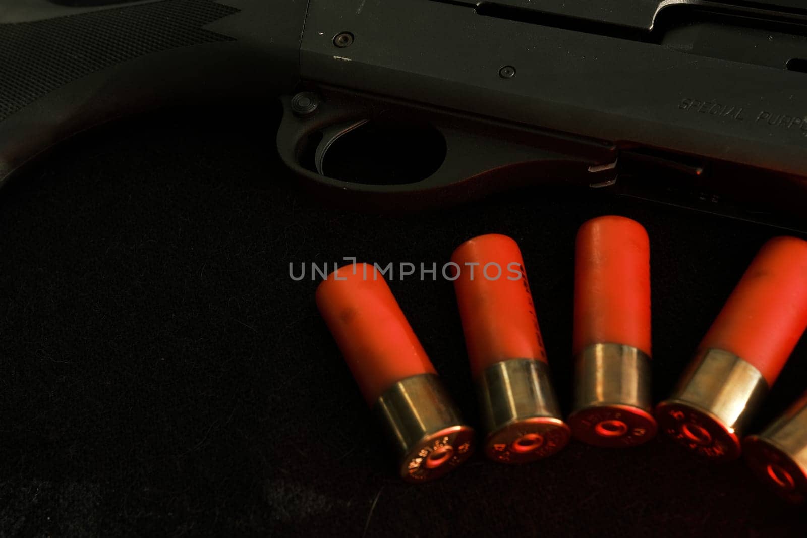 Trigger of a rifle on black background with red lightning with Shotgun shells on a black surface. Ammunition for 12 gauge smoothbore weapons. Hunting ammunition. Dark background