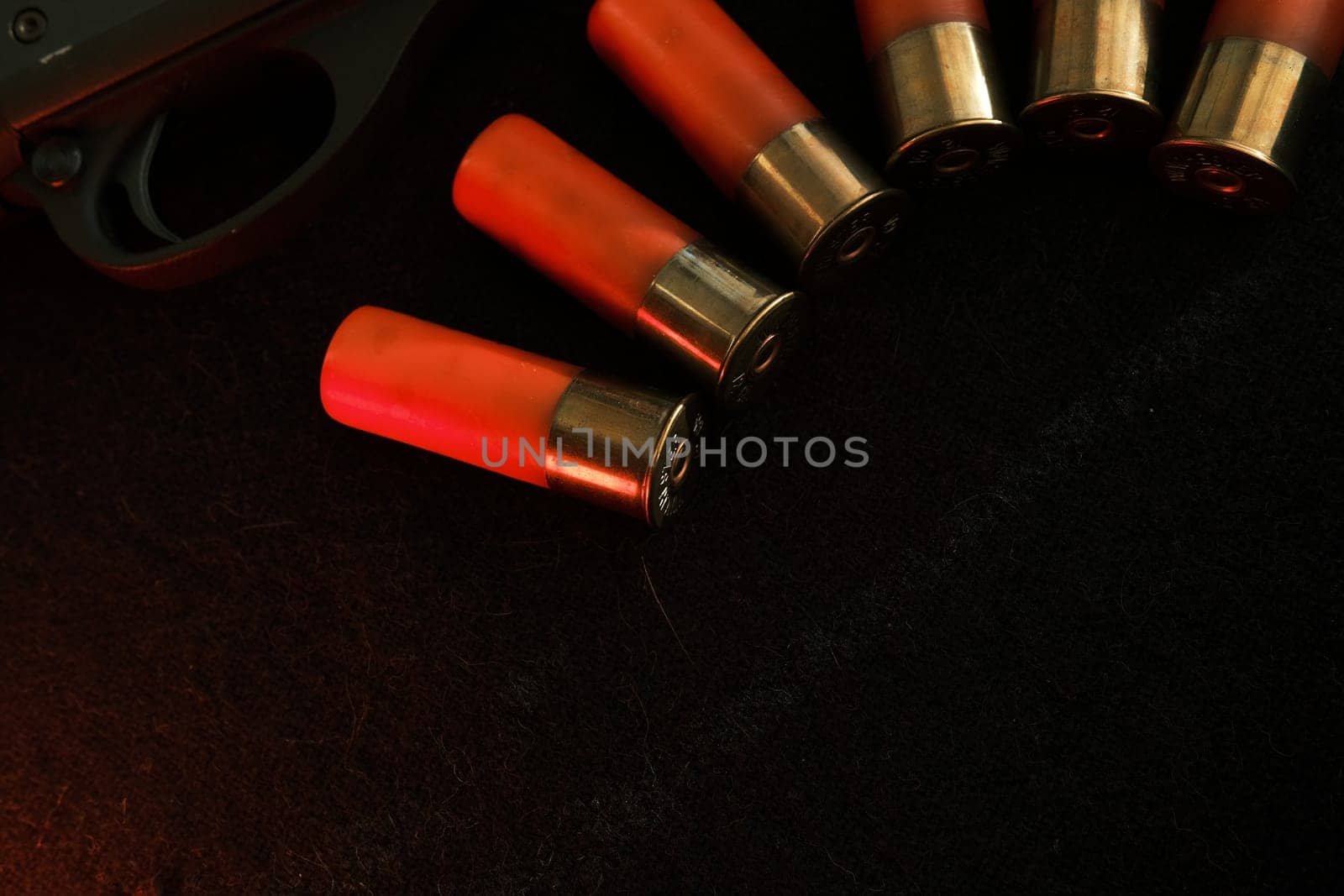 Trigger of a rifle on black background with red lightning with Shotgun shells on a black surface. Ammunition for 12 gauge smoothbore weapons. Hunting ammunition. Dark background