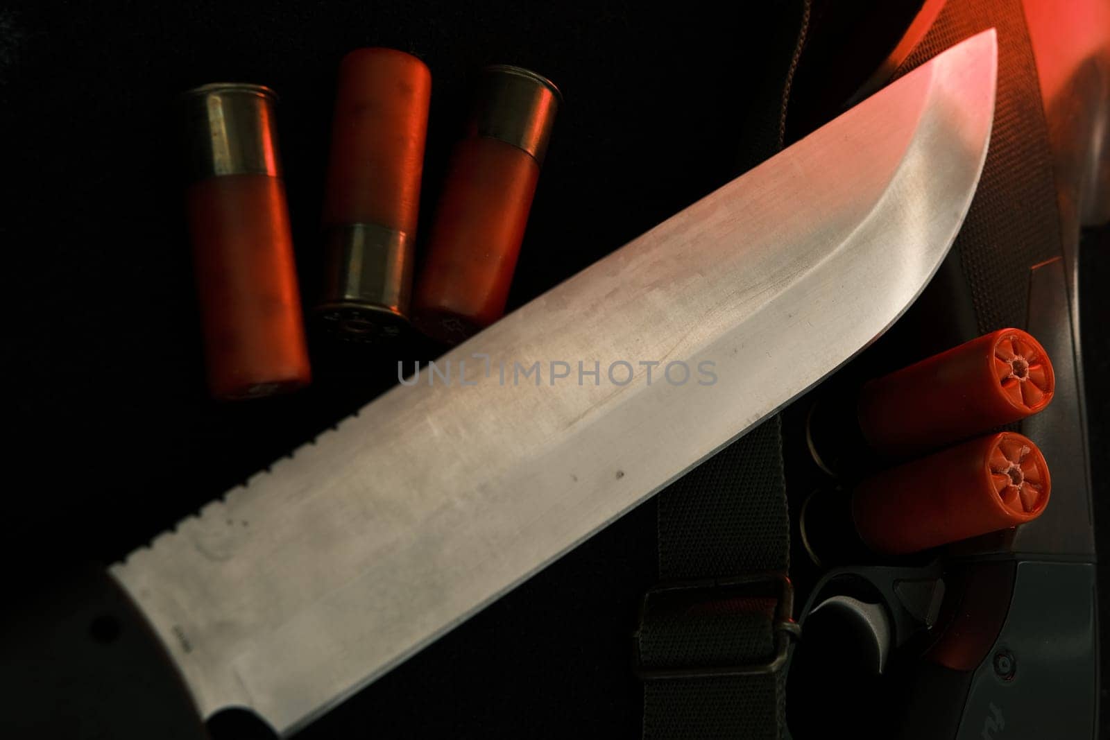 Weapon on black cloth: knife, rifle, shells,top view. Top view of knife, rifle shells