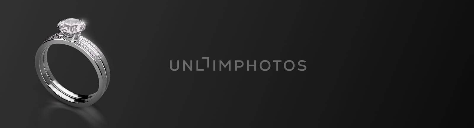 Elegant diamond ring on black background, wide image. 3d render