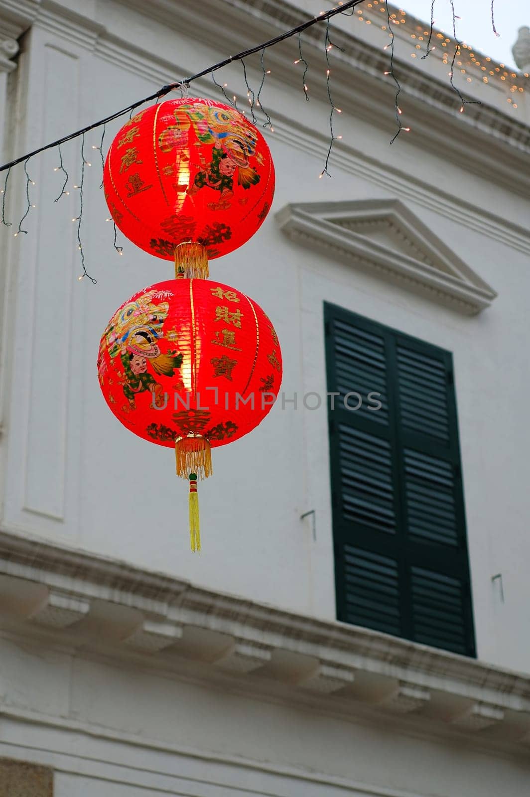 Two Chinese lanterns hanging in front of colonial house window