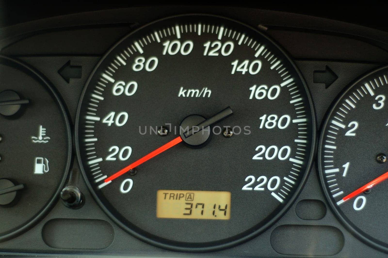 A close up of car dashboard with speed over black background