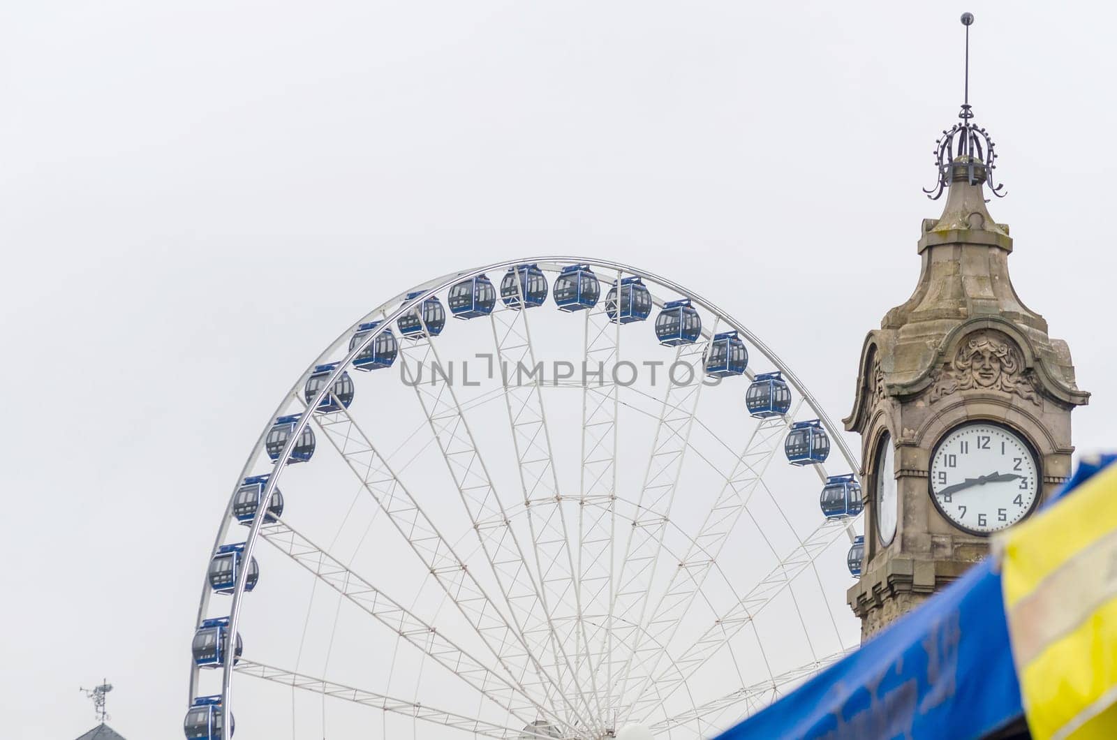 Historic Rhine water column on the Rhine promenade at Burgplatz near Düsseldorf's Old Town. In the background a Ferris wheel.